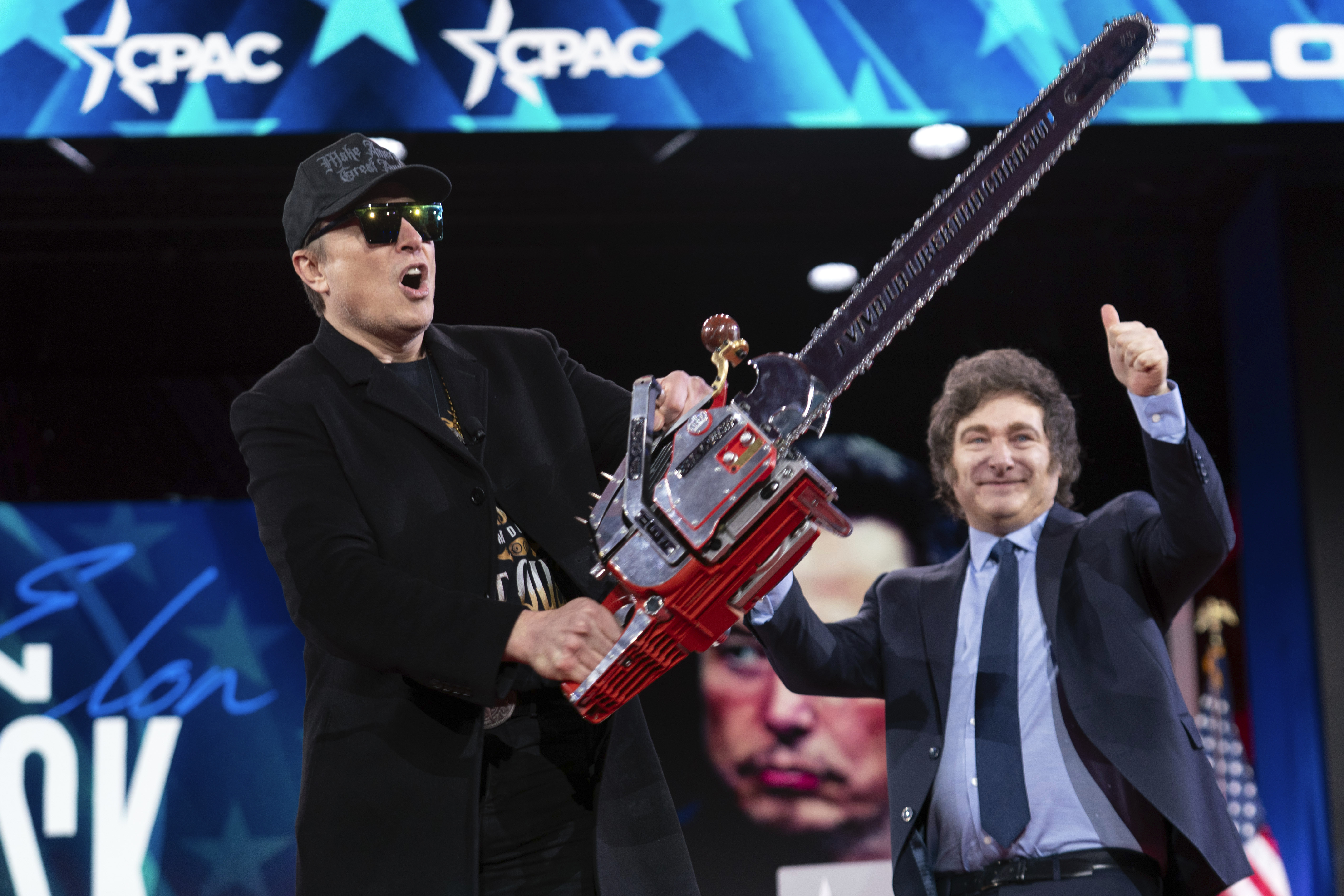 FILE - Elon Musk holds up a chainsaw he received from Argentina's President Javier Milei, right, as they arrive to speak at the Conservative Political Action Conference, CPAC, at the Gaylord National Resort & Convention Center, Feb. 20, 2025, in Oxon Hill, Md. (AP Photo/Jose Luis Magana, File)