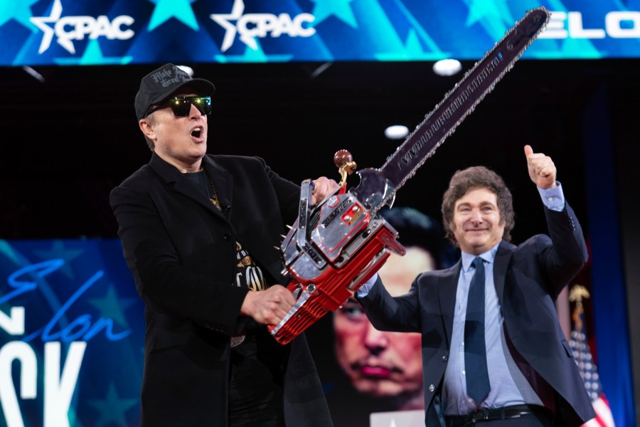 FILE - Elon Musk holds up a chainsaw he received from Argentina's President Javier Milei, right, as they arrive to speak at the Conservative Political Action Conference, CPAC, at the Gaylord National Resort & Convention Center, Feb. 20, 2025, in Oxon Hill, Md. (AP Photo/Jose Luis Magana, File)