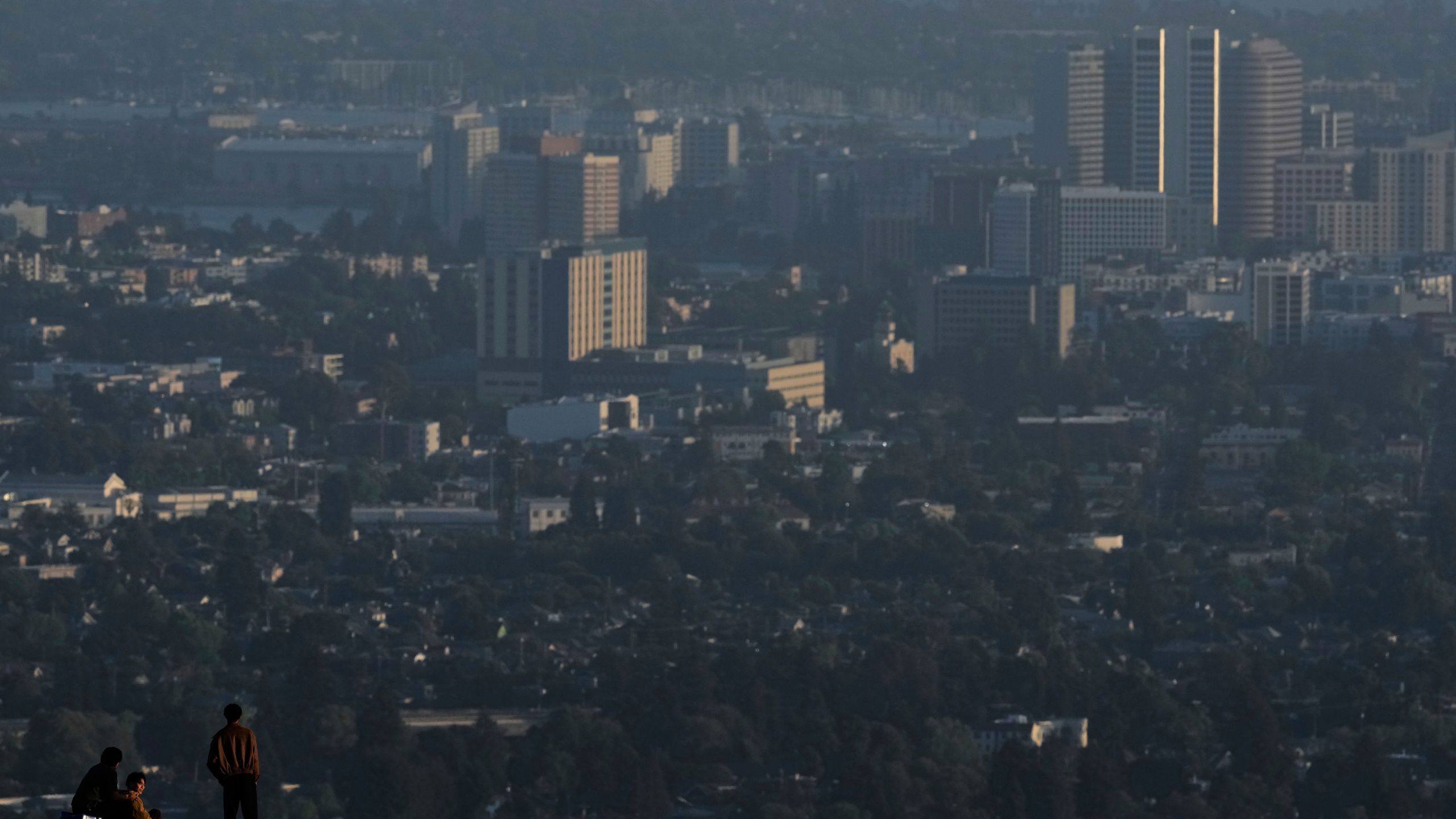People stop on a trail facing downtown Oakland, Tuesday, May 27, 2025, in Berkeley, Calif. (AP Photo/Godofredo A. Vásquez)