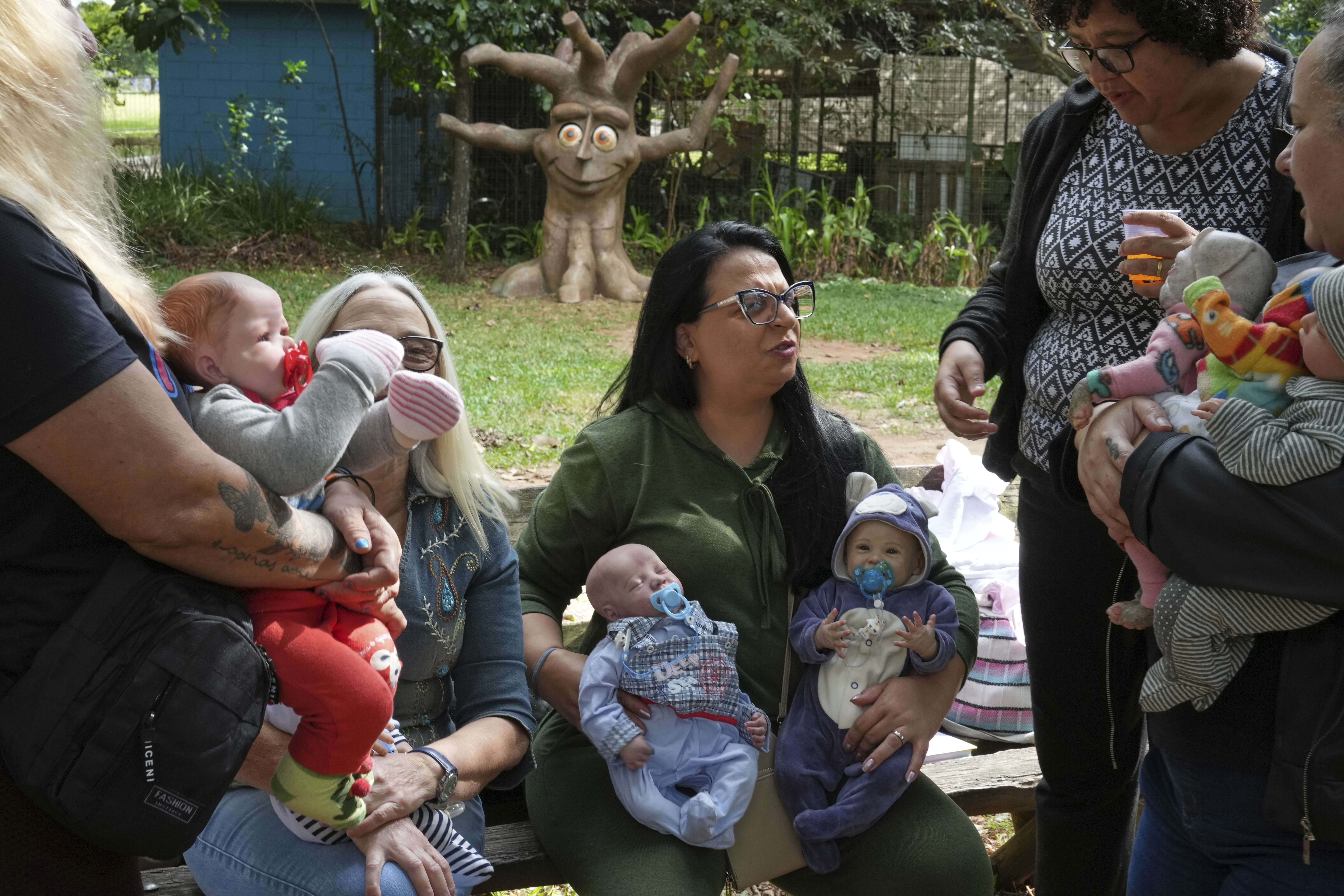 A group of women gather in a park to bond and show off their hyper-realistic reborn baby dolls, in Sao Paulo, Saturday, May 24, 2025. (AP Photo/Andre Penner)