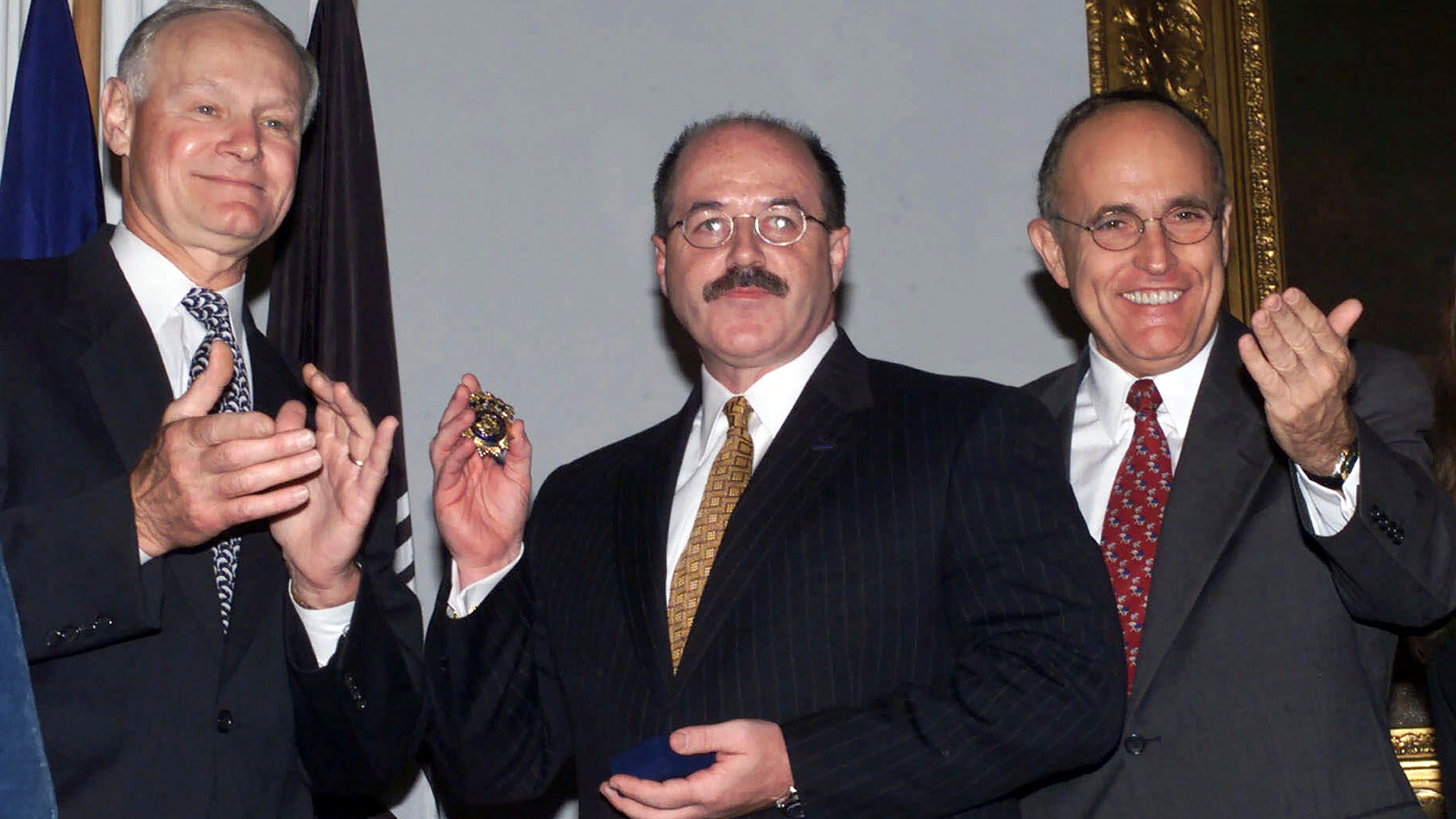 FILE— Former Police Commissioner Howard Safir, left, presents the official police commissioner's badge to the newly named New York City police commissioner, Bernard Kerik, center, as Mayor Rudolph Giuliani looks on, at New York's City Hall, Aug. 19, 2000. (AP Photo/Ed Bailey, File)