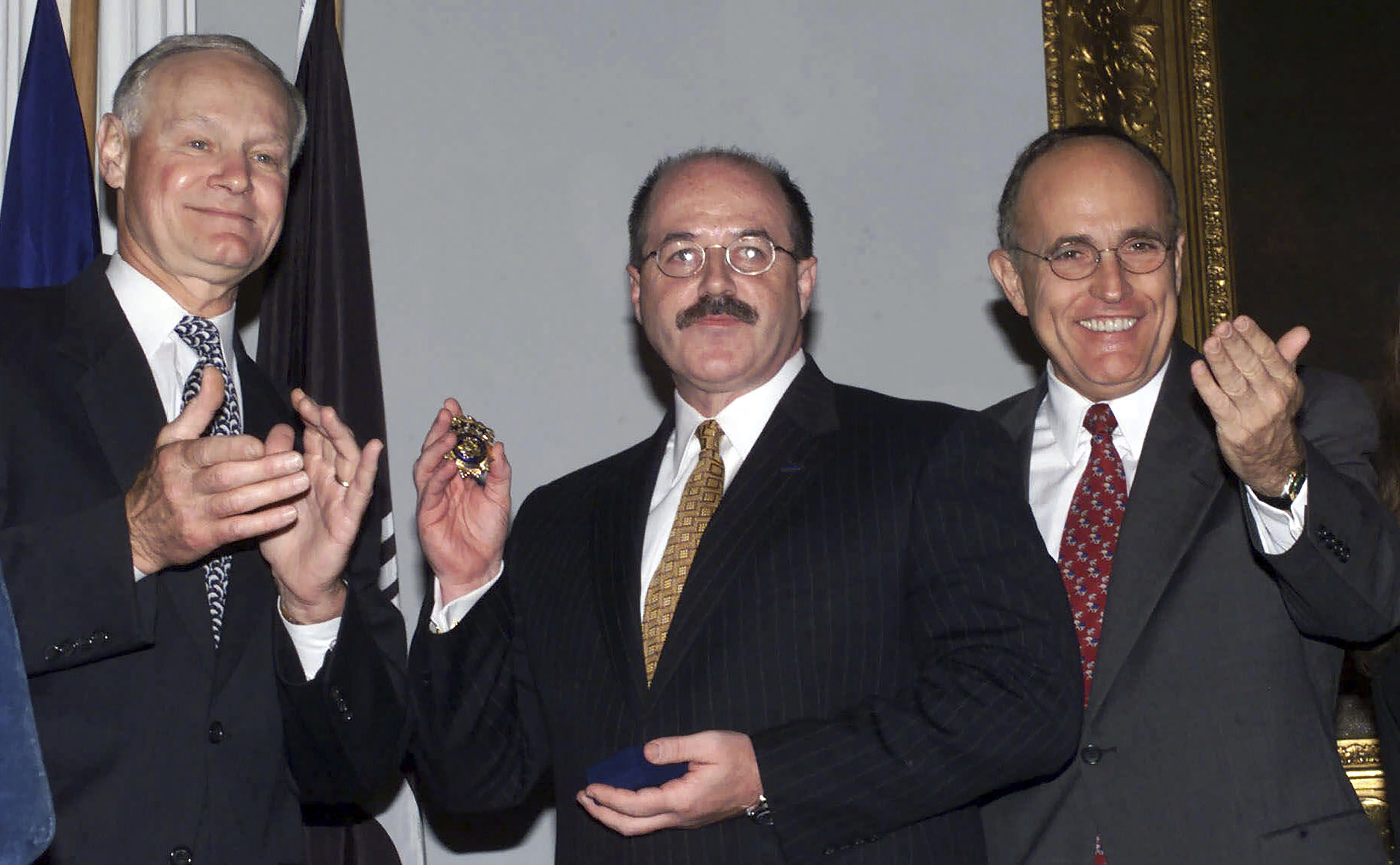 FILE— Former Police Commissioner Howard Safir, left, presents the official police commissioner's badge to the newly named New York City police commissioner, Bernard Kerik, center, as Mayor Rudolph Giuliani looks on, at New York's City Hall, Aug. 19, 2000. (AP Photo/Ed Bailey, File)