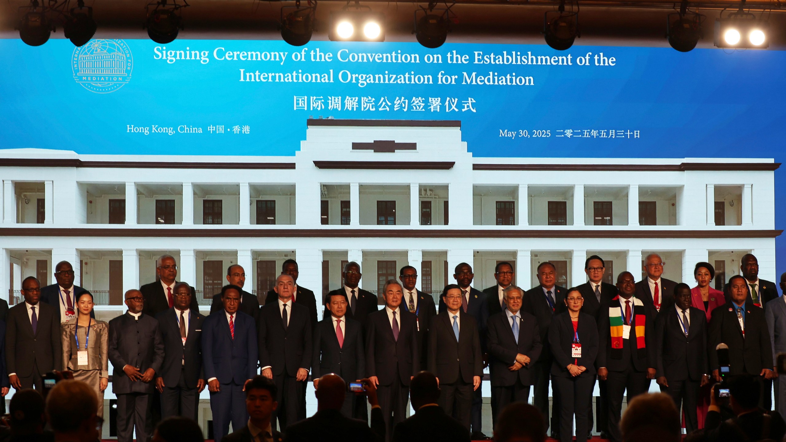 Chinese Foreign Minister Wang Yi, center, attends the signing ceremony of “the Convention on the Establishment of the International Organization for Mediation”, in Hong Kong, Friday, May 30, 2025. (AP Photo/Jonathan Lee)