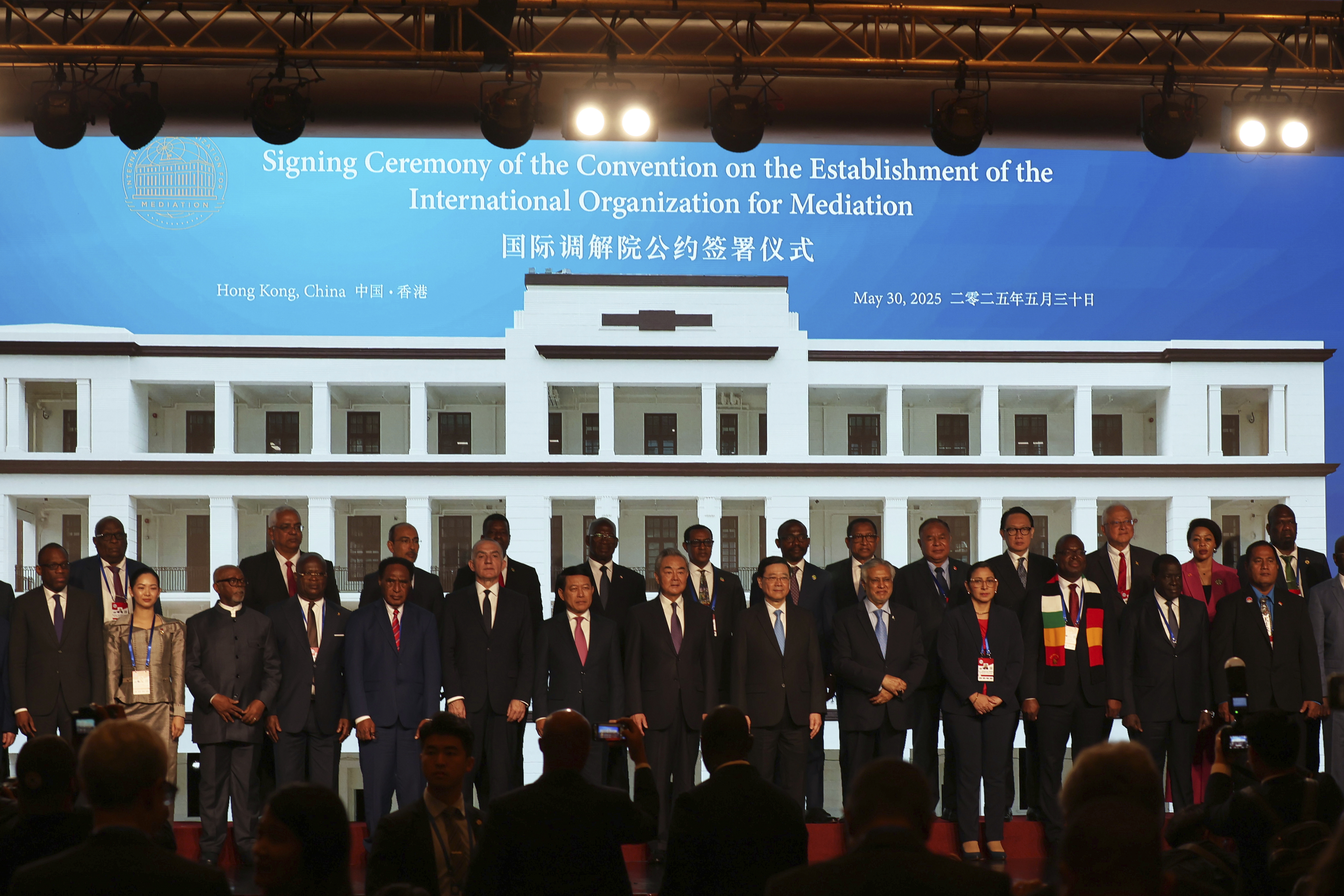 Chinese Foreign Minister Wang Yi, center, attends the signing ceremony of “the Convention on the Establishment of the International Organization for Mediation”, in Hong Kong, Friday, May 30, 2025. (AP Photo/Jonathan Lee)