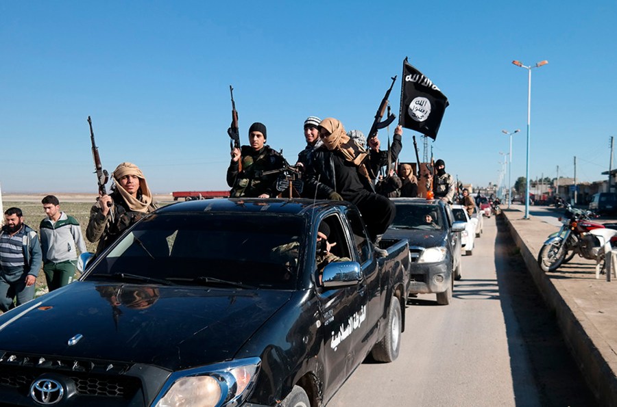 FILE - In this file photo released on May 4, 2015, by a militant website, which has been verified and is consistent with other AP reporting, Islamic State militants drive in a convoy through Tel Abyad, northeast Syria. (Militant website via AP, File)