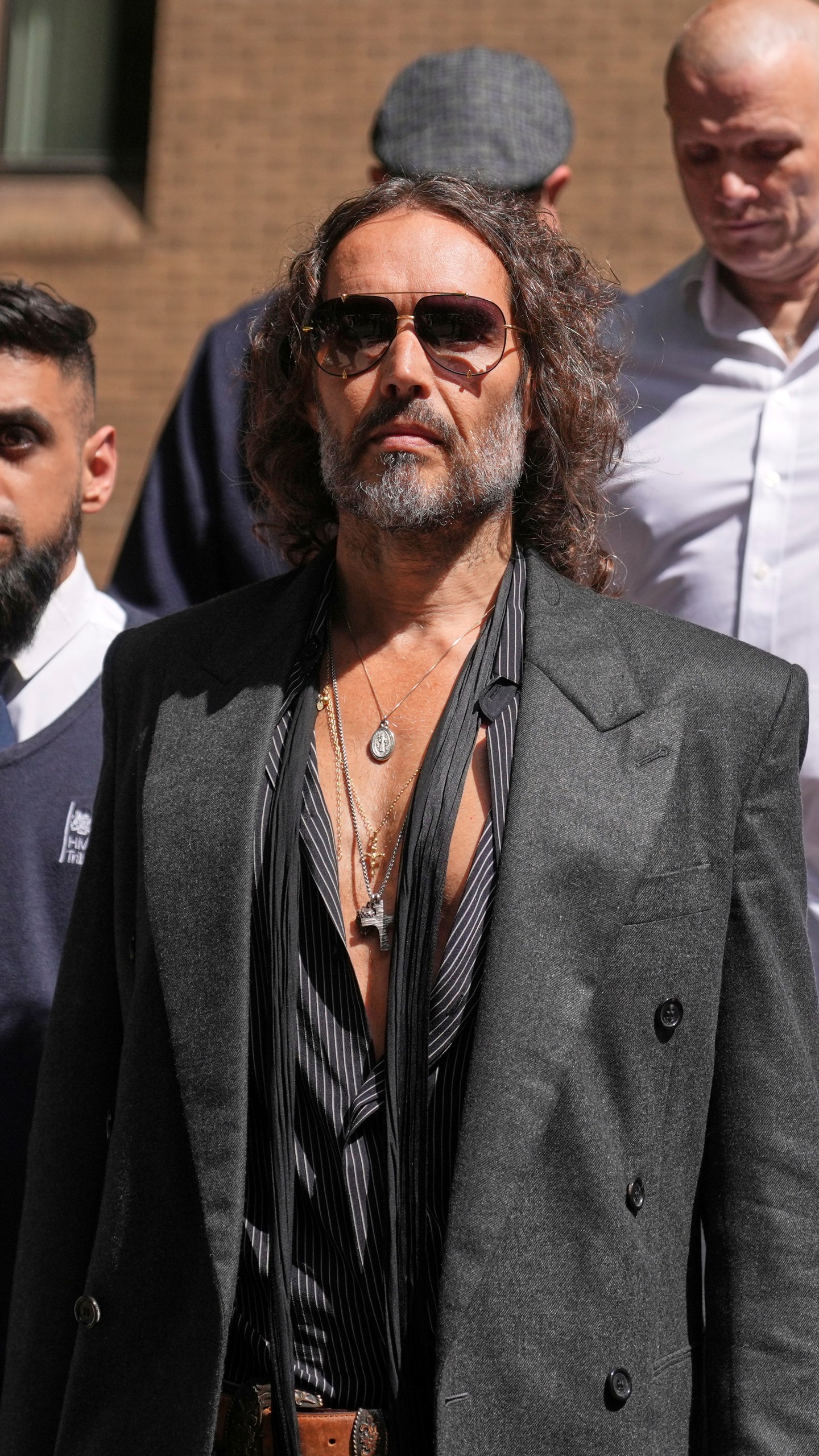 English comedian and actor Russell Brand leaves Southwark Crown Court where he is charged with rape and sexual assault in London, Friday, May 30, 2025.(AP Photo/Alastair Grant)