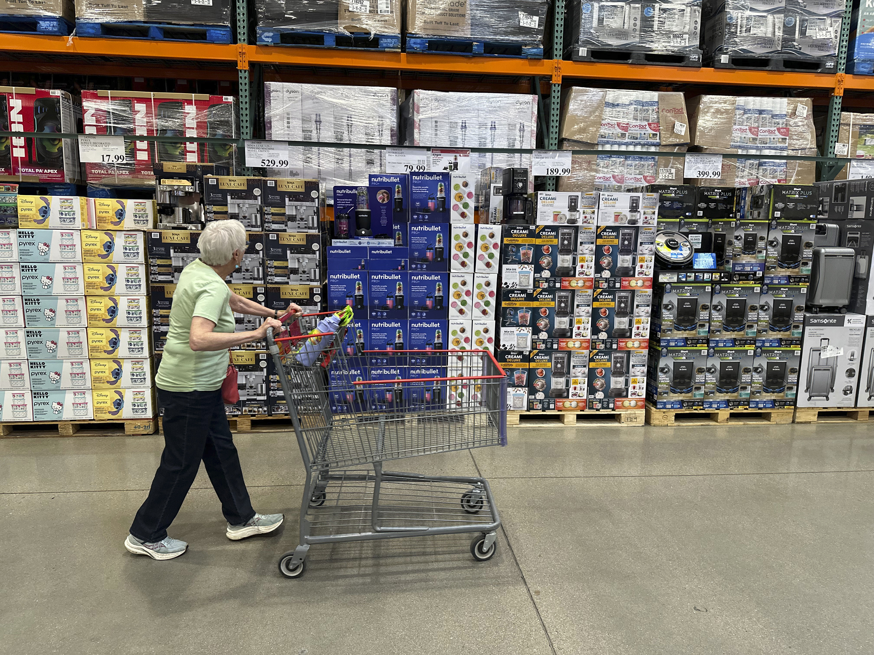 A shopper surveys goods on display in a Costco warehouse Wednesday, May 21, 2025, in Lone Tree, Colo. (AP Photo/David Zalubowski)