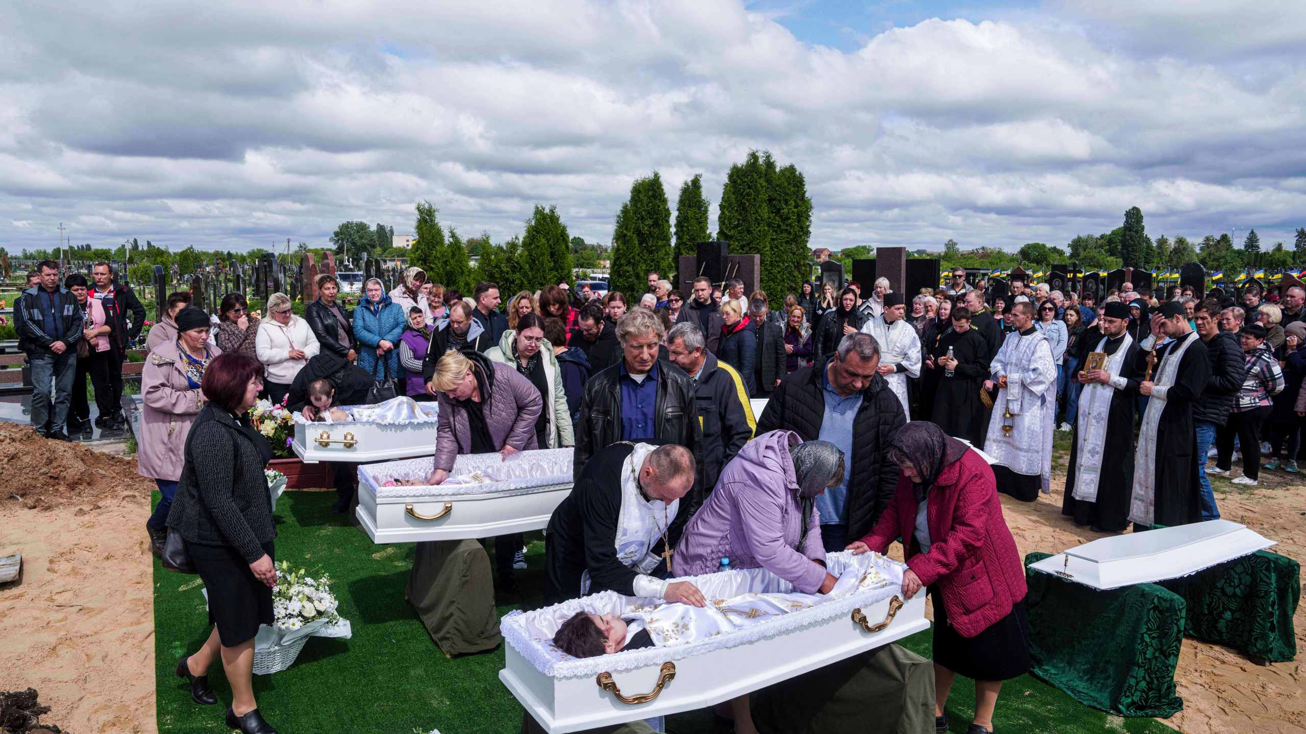 Relatives say goodbye to children Roman Martyniuk, 17, Tamara Martyniuk, 8, and Stanislav Martyniuk, 12, killed in a Russian strike on Sunday, during farewell ceremony in Korostyshiv, Zhytomyr region, Ukraine, Wednesday, May 28, 2025. (AP Photo/Evgeniy Maloletka)