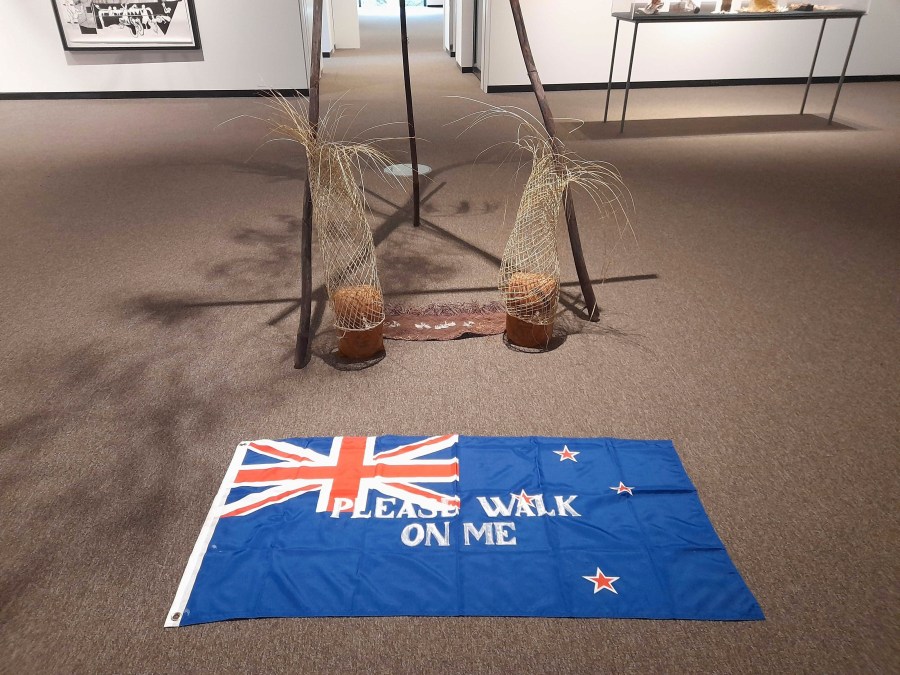 An artwork titled Flagging the Future, a cloth New Zealand flag with the words "please walk on me" stenciled across it by Māori artist Diane Prince, is displayed on the floor on Tuesday, May 27, 2025, at the Suter Art Gallery in Nelson, New Zealand. (Catherine Hubbard/Nelson Mail/STUFF via AP)