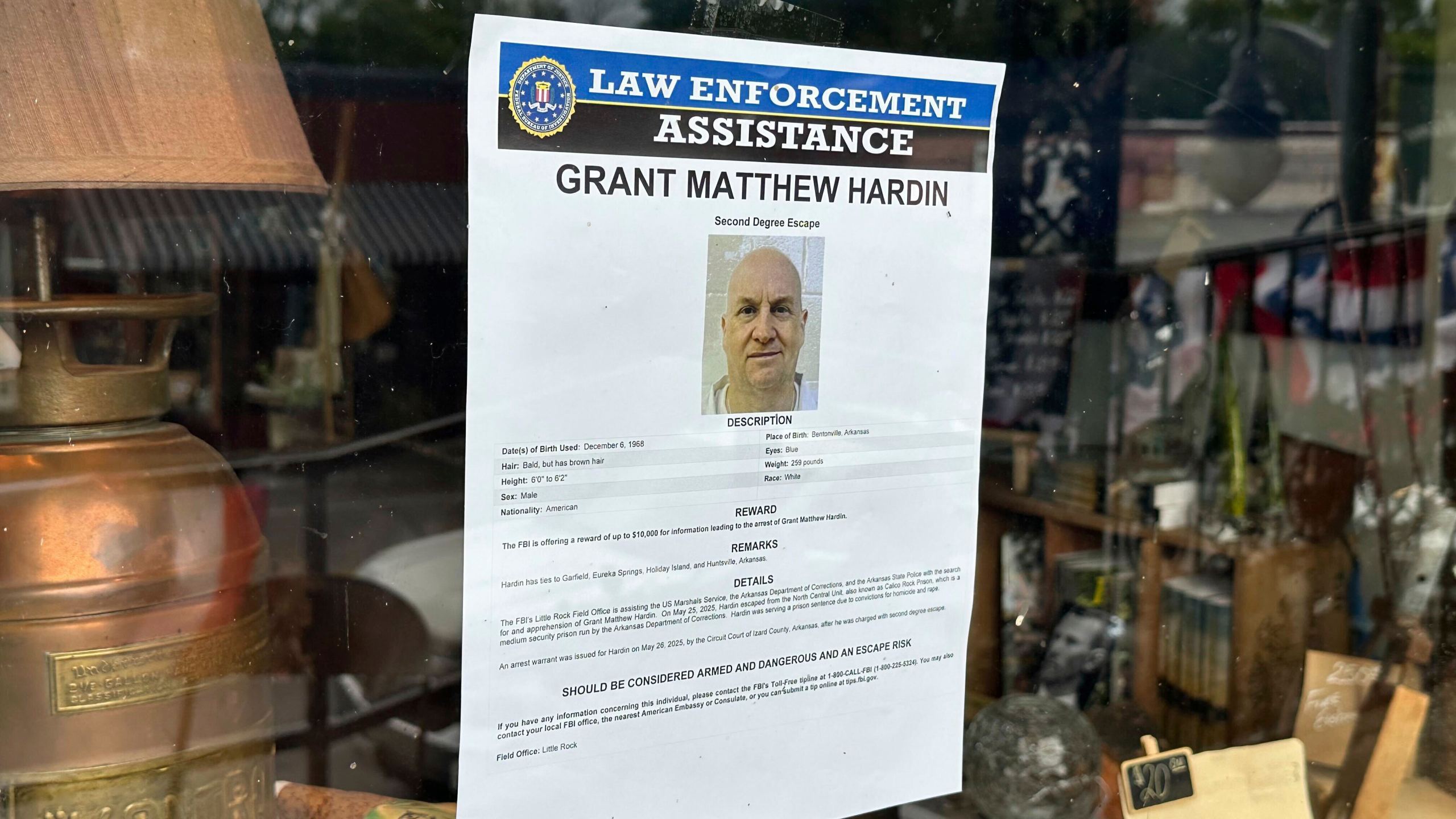 A flier looking for Grant Hardin hangs on the glass of a business, Thursday, May 29, 2025, in downtown Calico Rockt, Ark. (AP Photo/Nicholas Ingram)