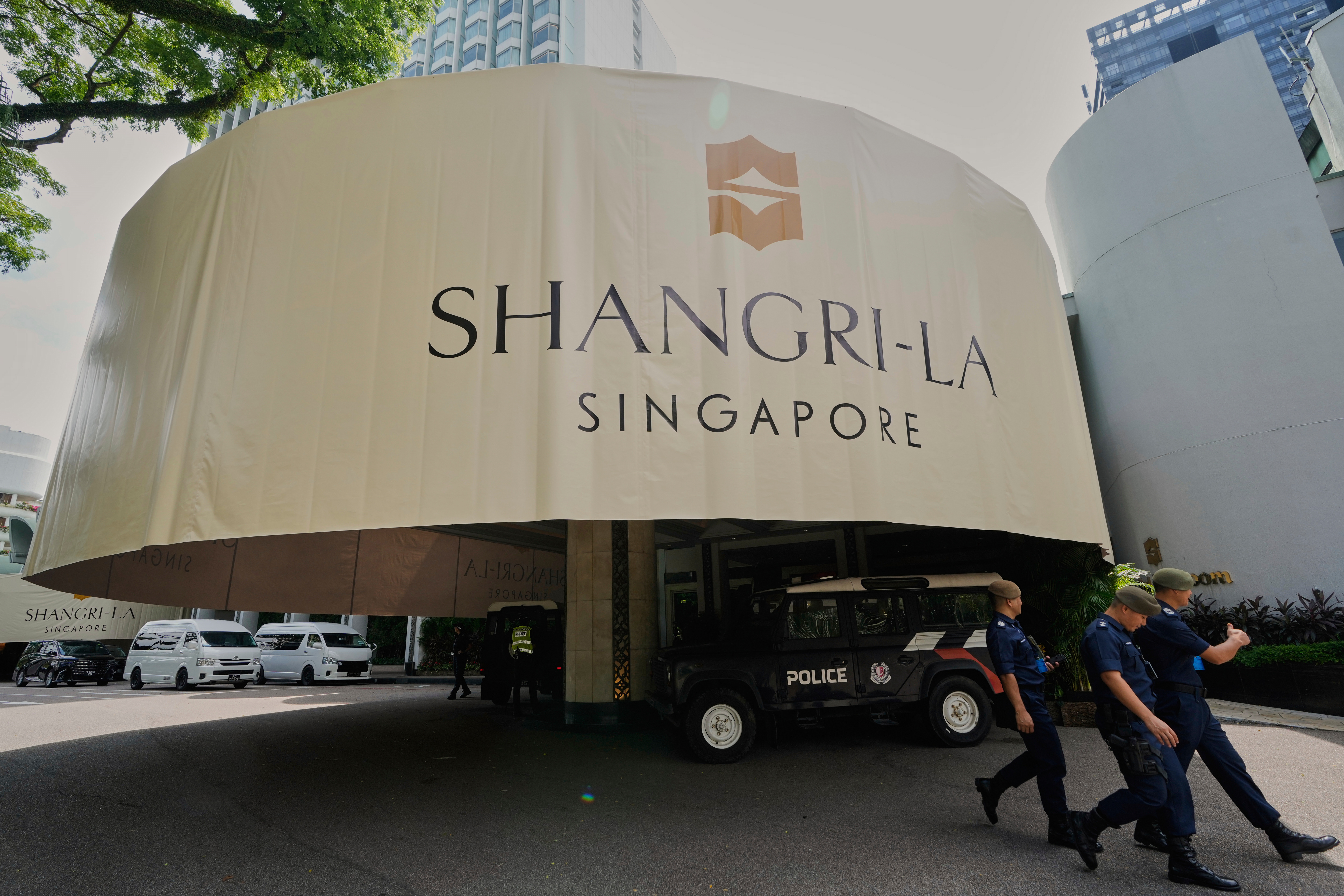 Police officials walk past the venue during the Shangri-La Dialogue summit in Singapore, Friday, May 30, 2025. (AP Photo/Anupam Nath)