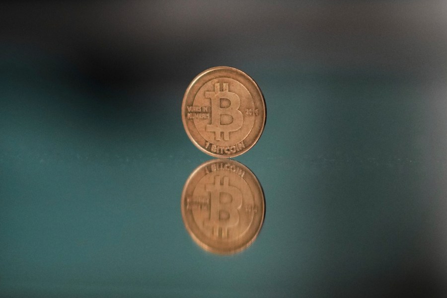 FILE - A bitcoin token is placed on a mirror for a photograph in Prague, Czech Republic, Sunday, May 11, 2025. (AP Photo/Petr David Josek, File)