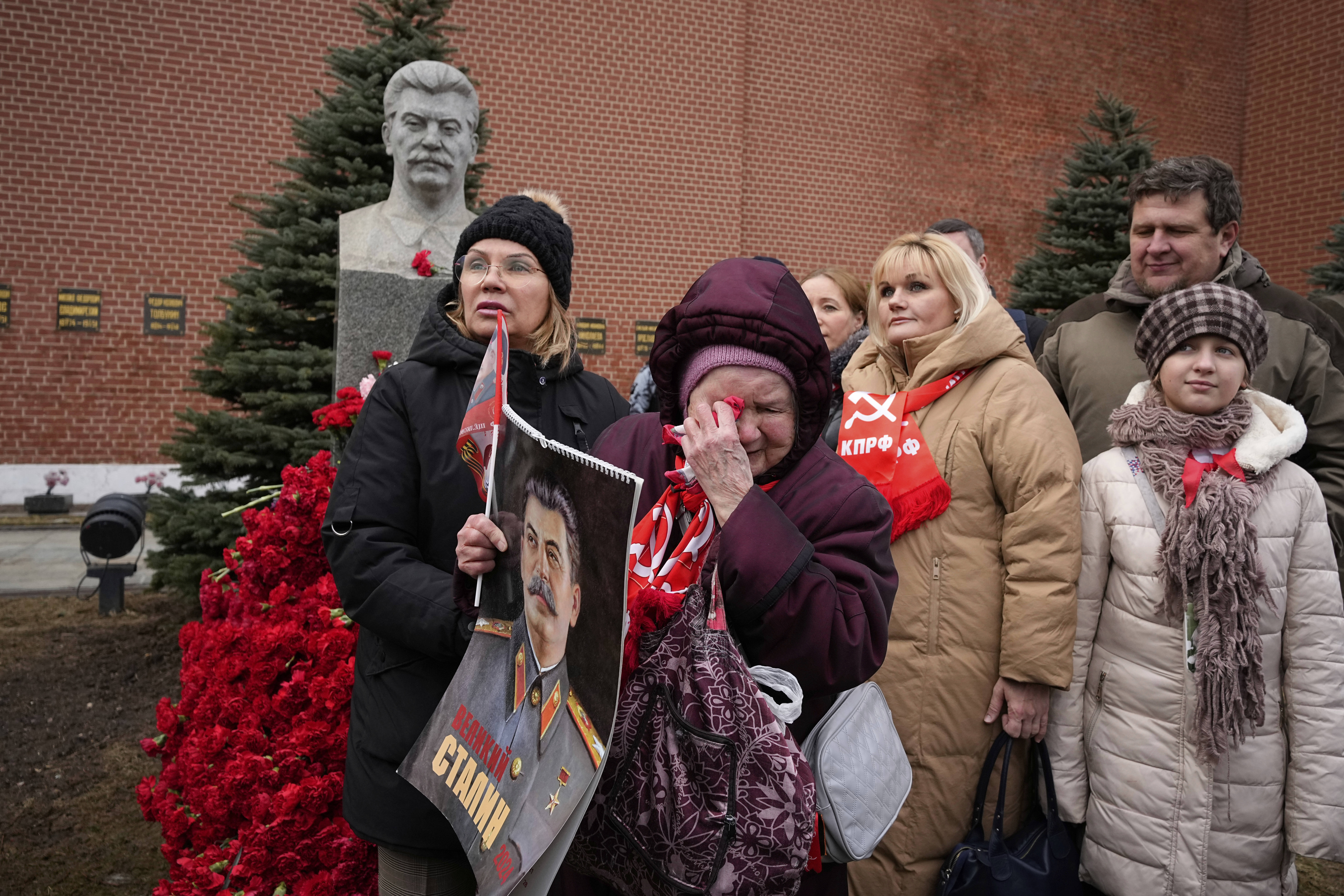 FILE - An elderly woman cries while holding a portrait of Soviet leader Josef Stalin after laying flowers at his grave near the Kremlin Wall in Red Square in Moscow on Wednesday, March 5, 2025, to mark the 72nd anniversary of his death. (AP Photo/Alexander Zemlianichenko, File)