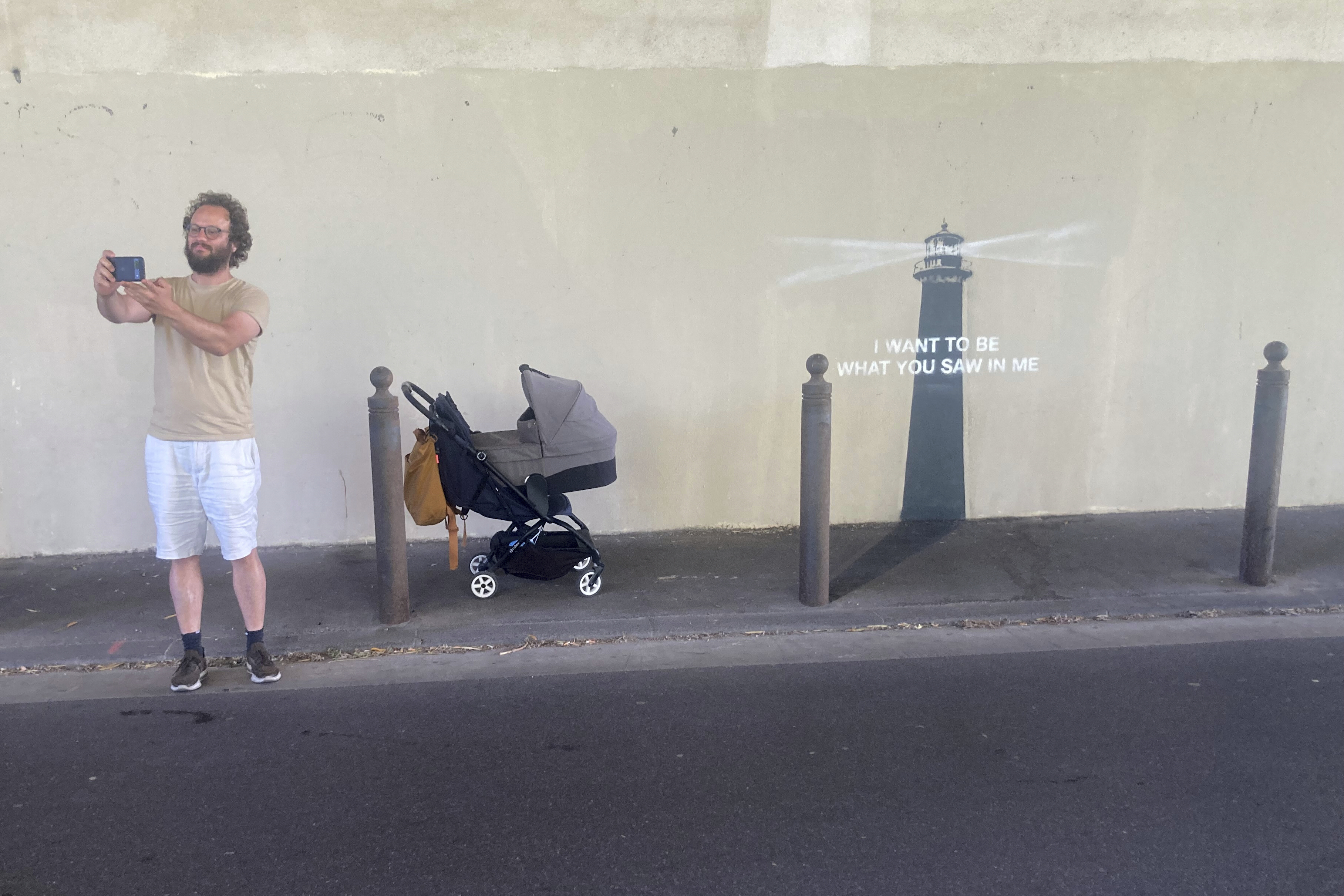 A man makes a selfie by an artwork by street artist Banksy, Friday, May 30, 2025 in Marseille, southern France. (AP Photo/Bishr Eltoni)