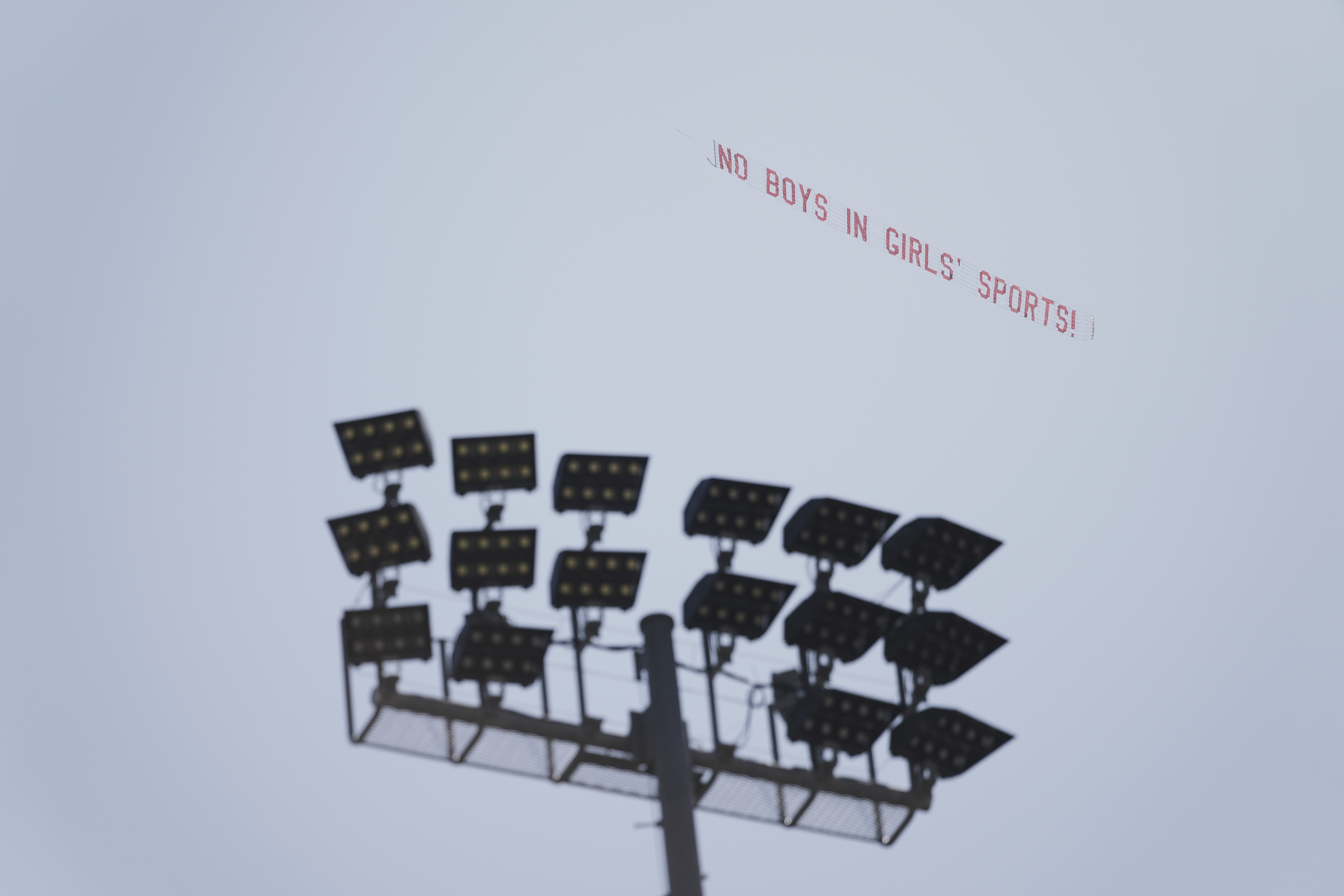 A banner reading "NO BOYS IN GIRLS' SPORTS!" is flown above Veteran's Memorial Stadium during the California high school track-and-field championships in Clovis, Calif., Friday, May 30, 2025. (AP Photo/Jae C. Hong)