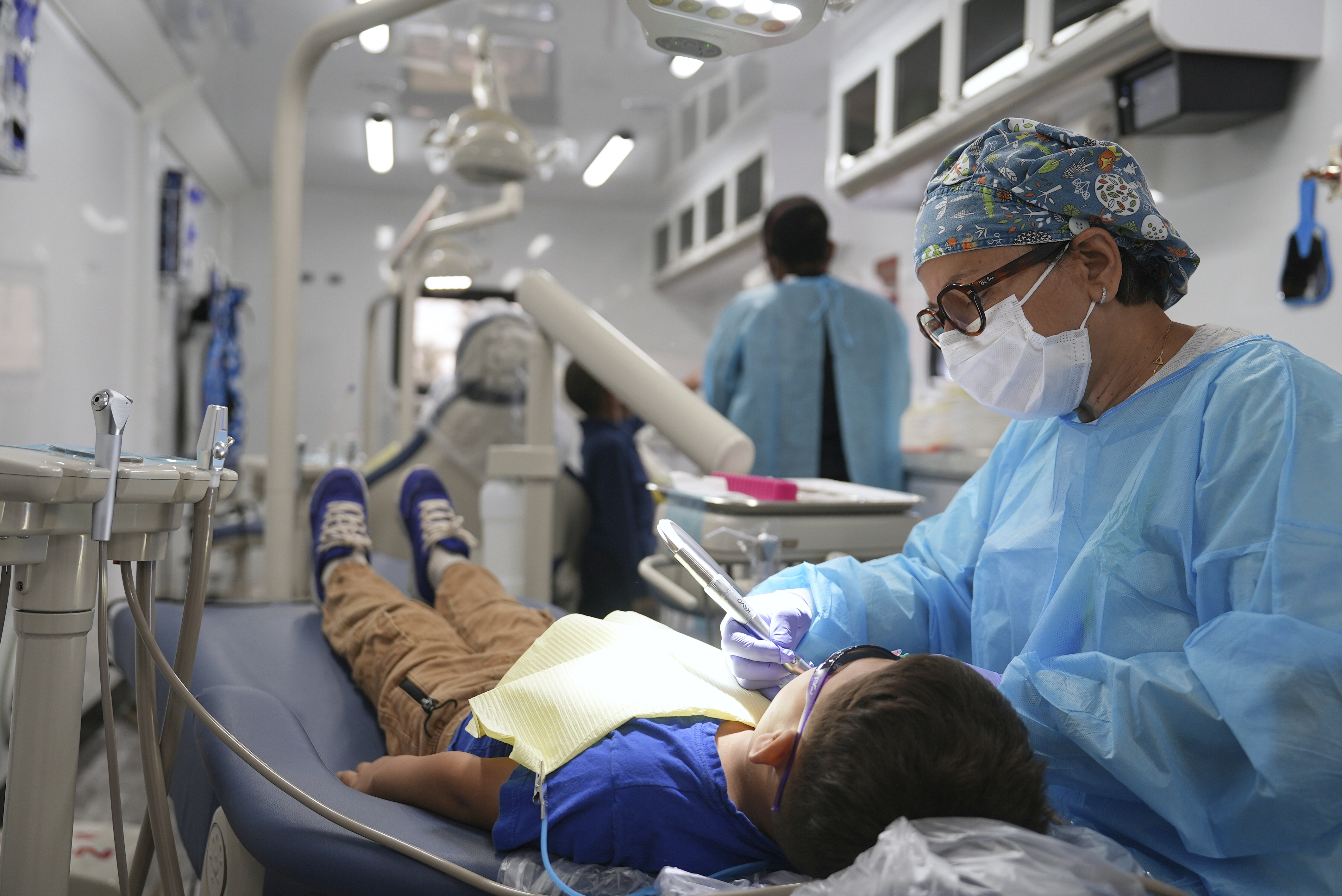 A dentist cleans the teeth of a child in the public health department’s mobile dental clinic visiting Starmount Elementary school in Charlotte, N.C., on March 20, 2025. (AP Photo/Mary Conlon)