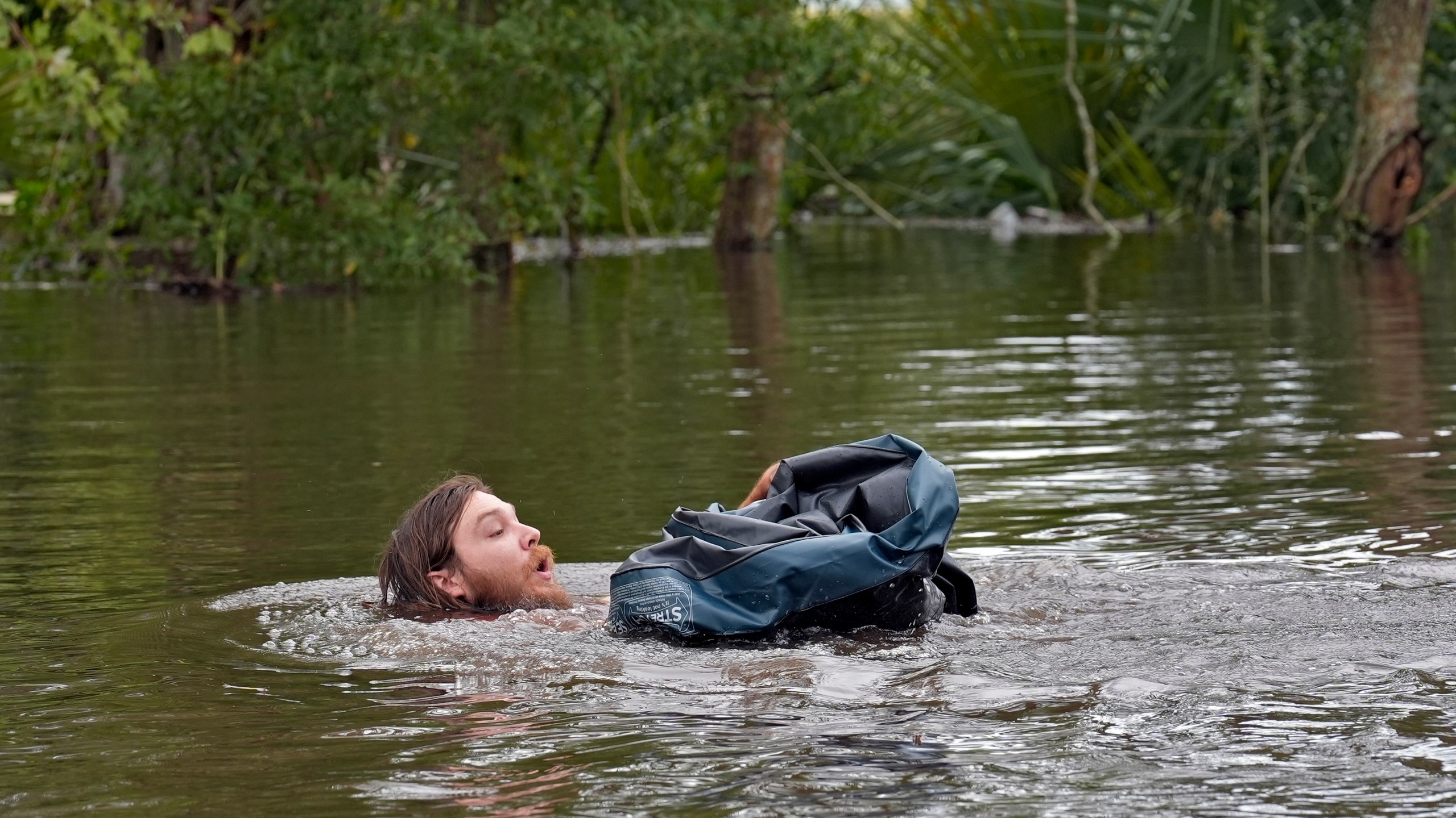 FILE - Connor Hughes of Lithia, Fla., moves in deep floodwaters from Hurricane Milton along the Alafia River, Oct. 11, 2024, in Lithia, Fla. (AP Photo/Chris O'Meara, File)