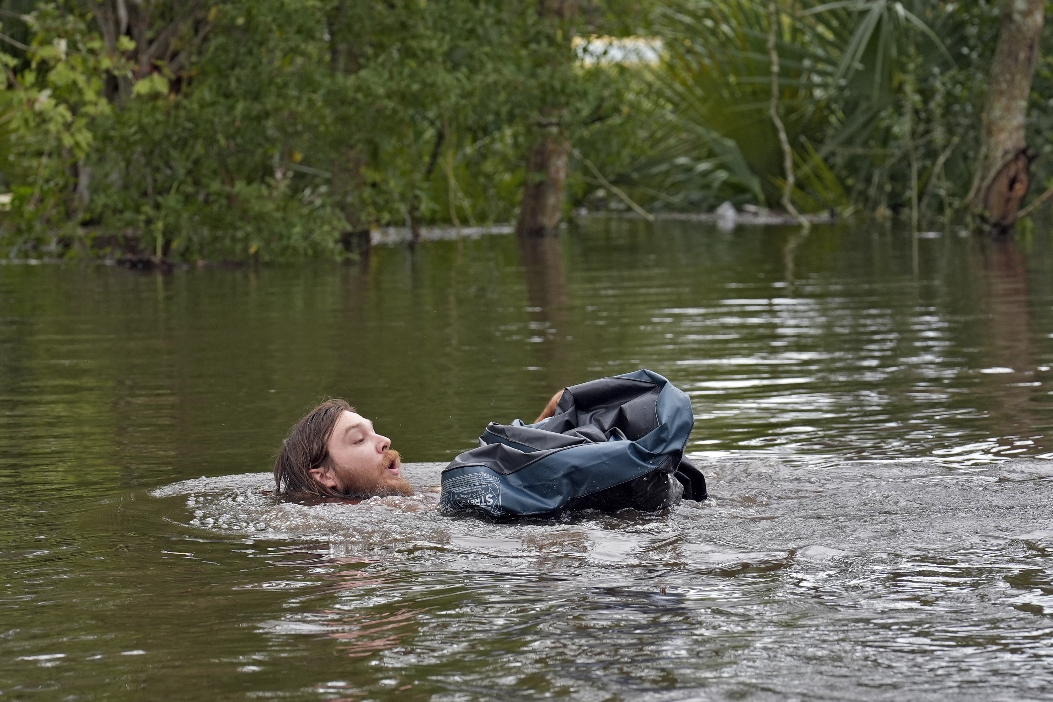 FILE - Connor Hughes of Lithia, Fla., moves in deep floodwaters from Hurricane Milton along the Alafia River, Oct. 11, 2024, in Lithia, Fla. (AP Photo/Chris O'Meara, File)