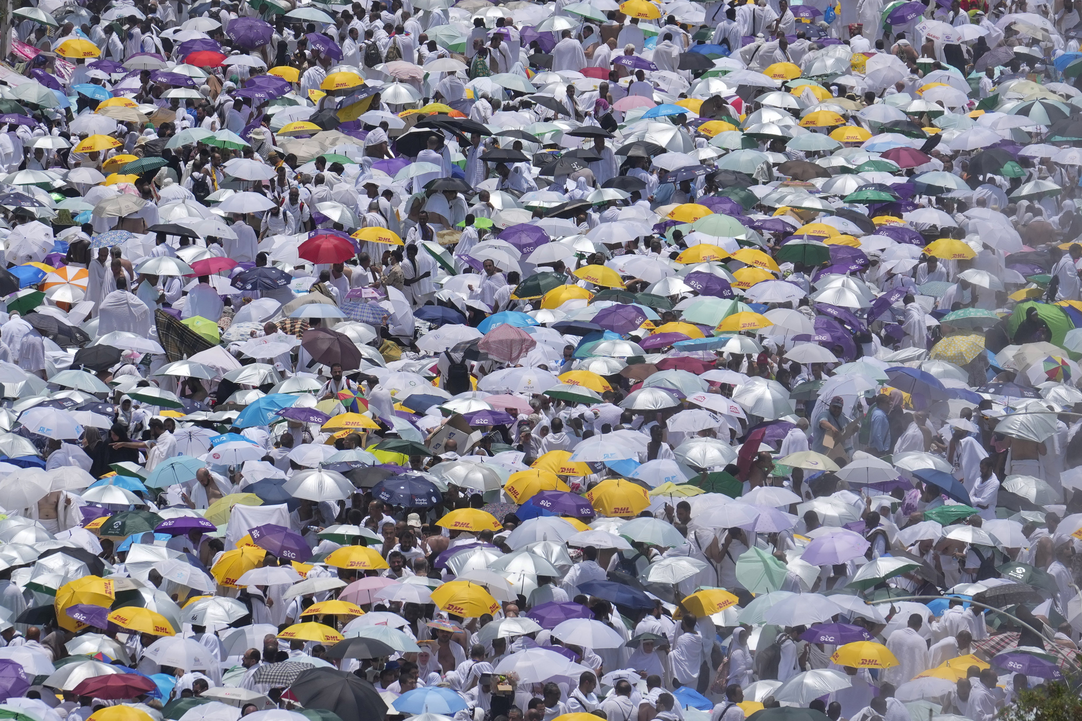 FILE - Muslim pilgrims use umbrellas to shield themselves from the sun as they gather outside Nimrah Mosque to offer the noon prayers in Arafat, on the second day of the annual hajj pilgrimage, near the holy city of Mecca, Saudi Arabia, Saturday, June 15, 2024. (AP Photo/Rafiq Maqbool, File)