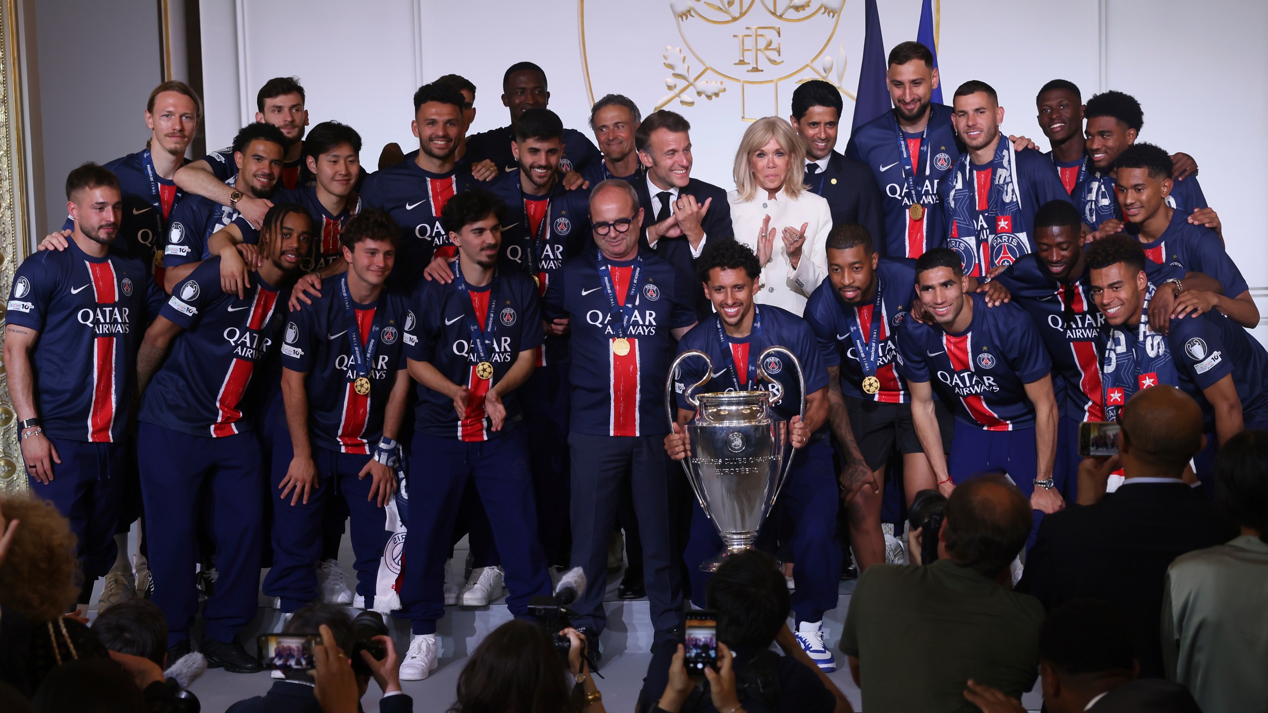 French President Emmanuel Macron, center left, his wife Brigitte Macron, pose with the PSG team after the team won the Champions League final soccer match between Paris Saint-Germain and Inter Milan Sunday, June 1, 2025 at the Elysee Palace in Paris. (AP Photo/Thomas Padilla, Pool)
