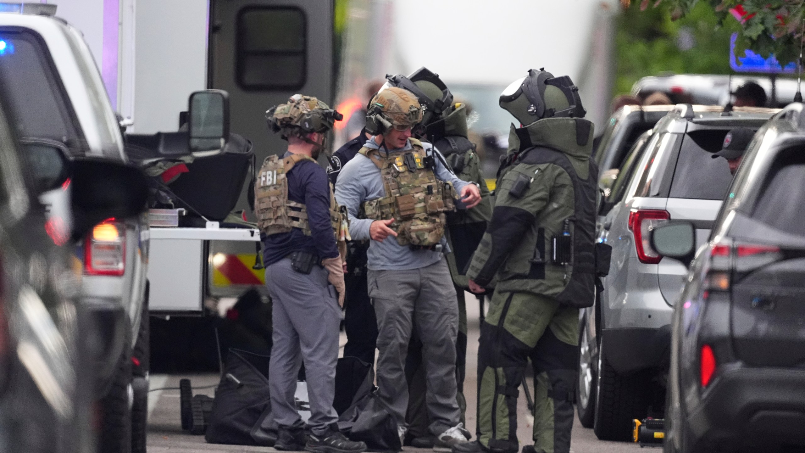 Law enforcement officials dress to investigate after an attack on the Peark Street Mall Sunday, June 1, 2025, in Boulder, Colo. (AP Photo/David Zalubowski)