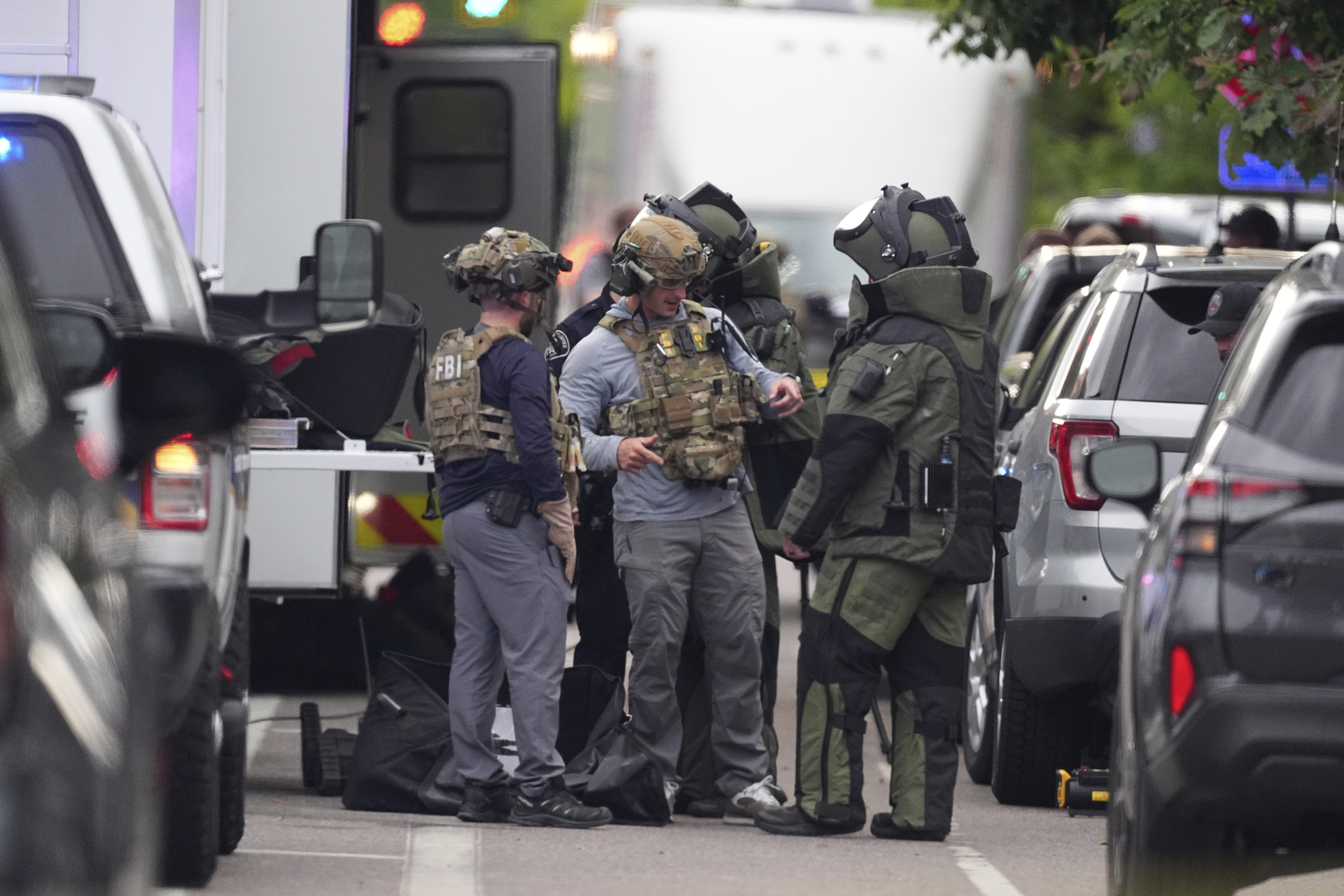 Law enforcement officials dress to investigate after an attack on the Peark Street Mall Sunday, June 1, 2025, in Boulder, Colo. (AP Photo/David Zalubowski)