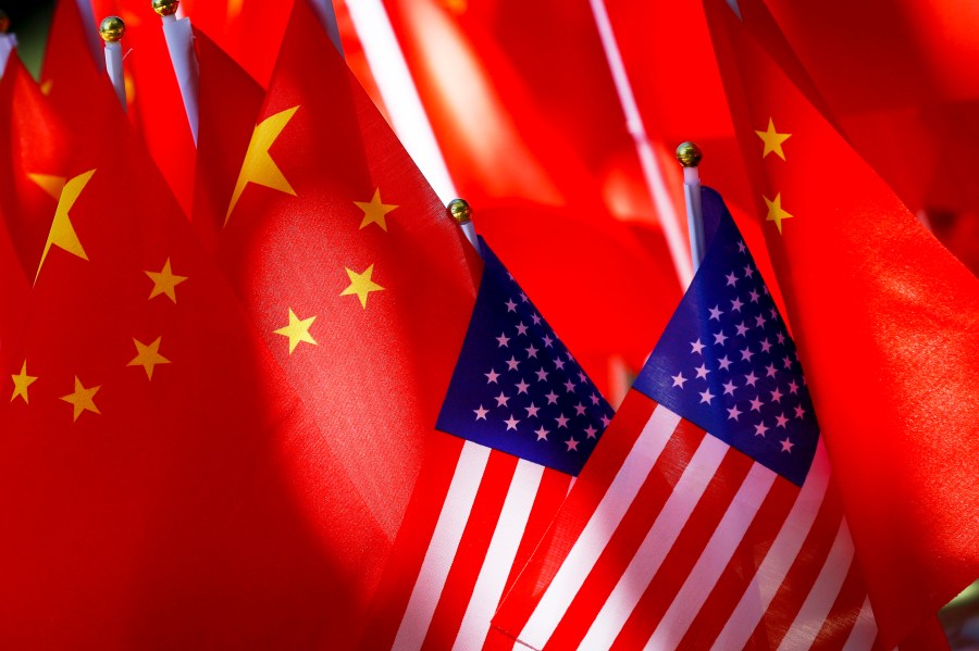 FILE - American flags are displayed together with Chinese flags on top of a trishaw on Sept. 16, 2018, in Beijing. (AP Photo/Andy Wong, File)