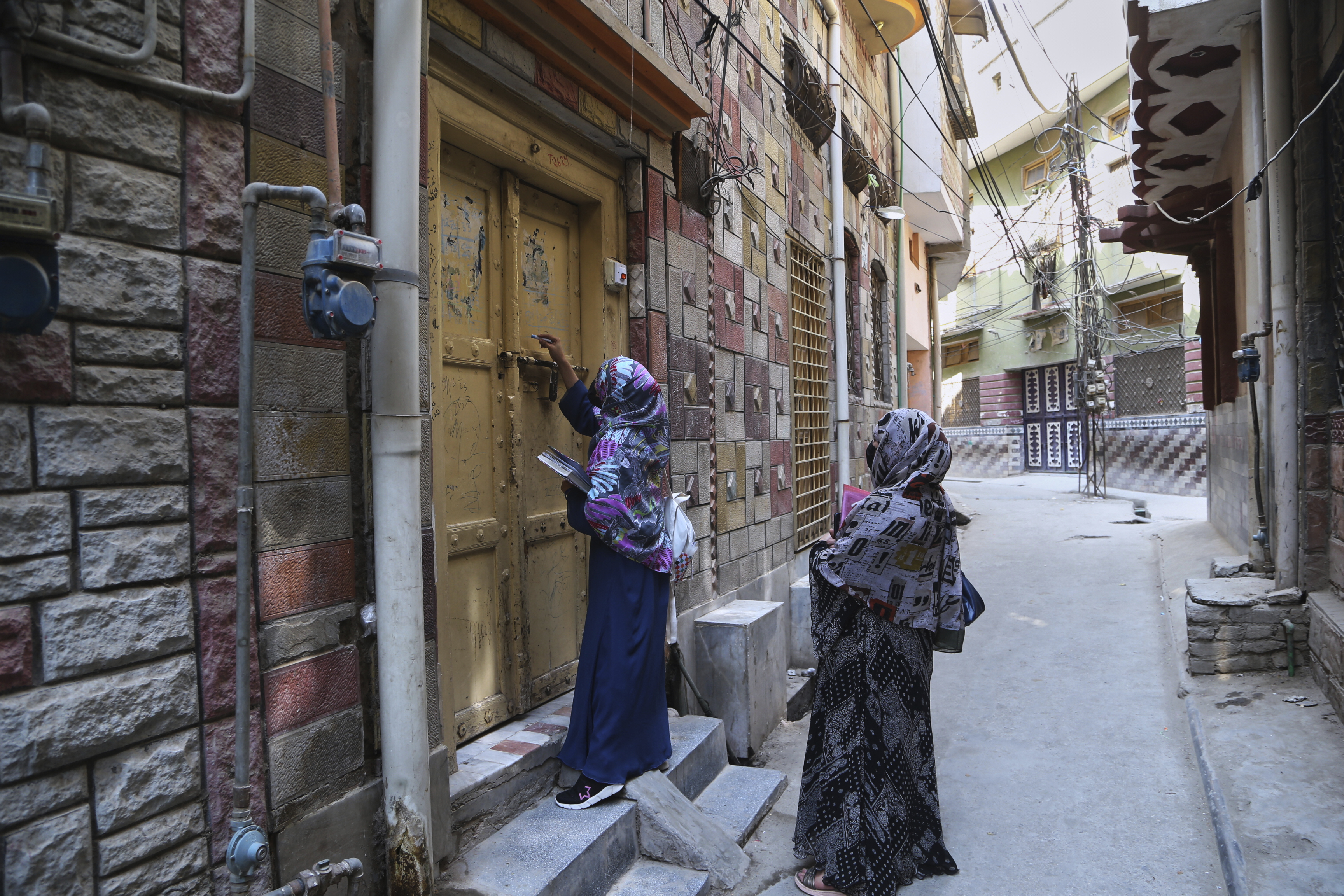 A health worker marks a house after administrating a polio vaccine to a child at a neighborhood in Peshawar, Pakistan, Monday, May 26, 2025. (AP Photo/Muhammad Sajjad)