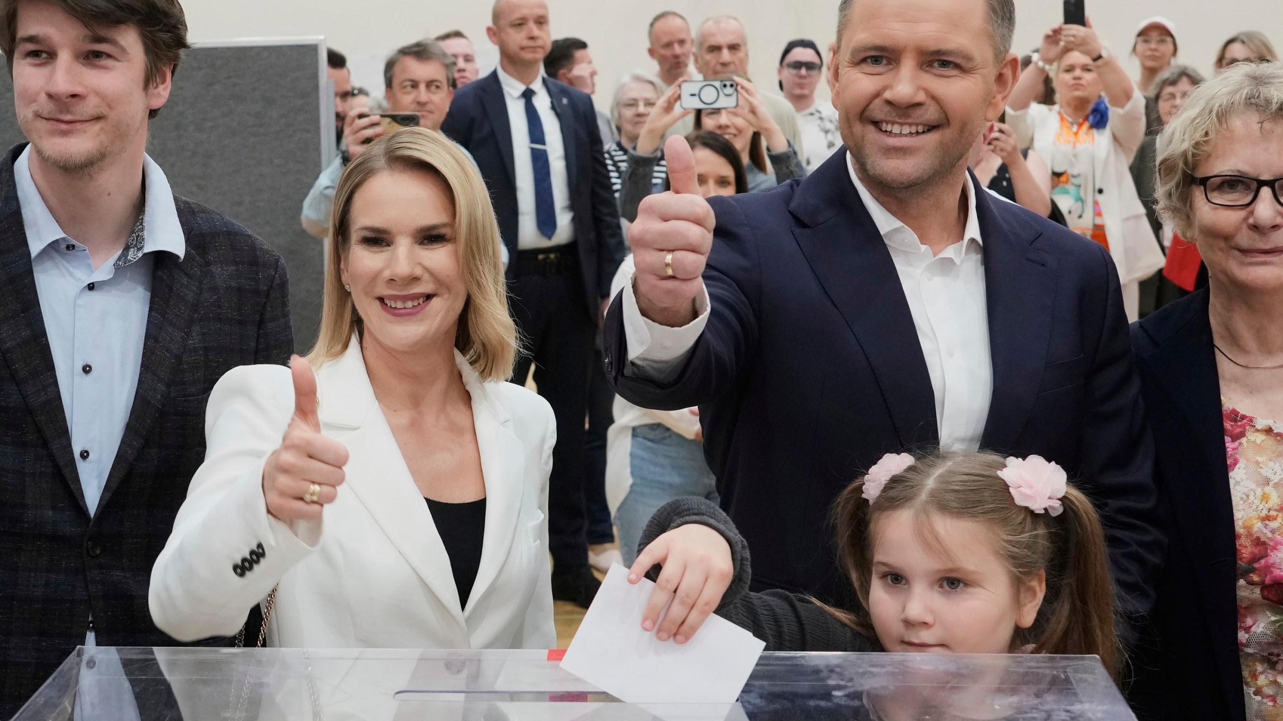 Presidential candidate Karol Nawrocki, second right, poses with his wife Marta Nawrocka, second left, and daughter Katarzyna at a polling station during the presidential election runoff in Warsaw, Poland, Sunday, June 1, 2025. (AP Photo/Czarek Sokolowski)