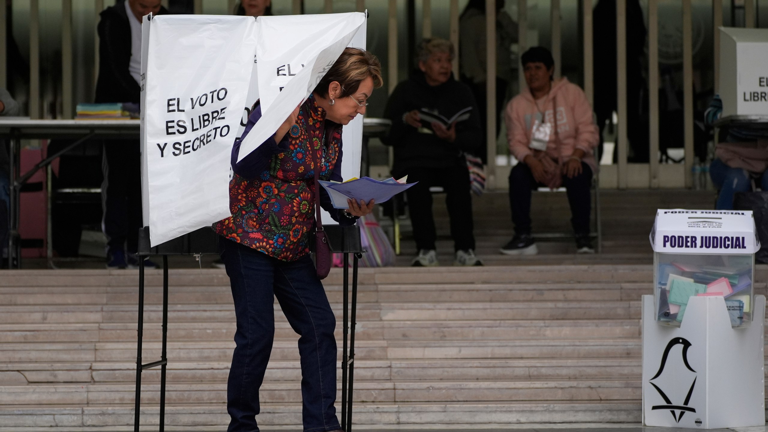 A voter leaves after casting her ballot in Mexico's first judicial elections, in Mexico City, Sunday, June 1, 2025. (AP Photo/Marco Ugarte)