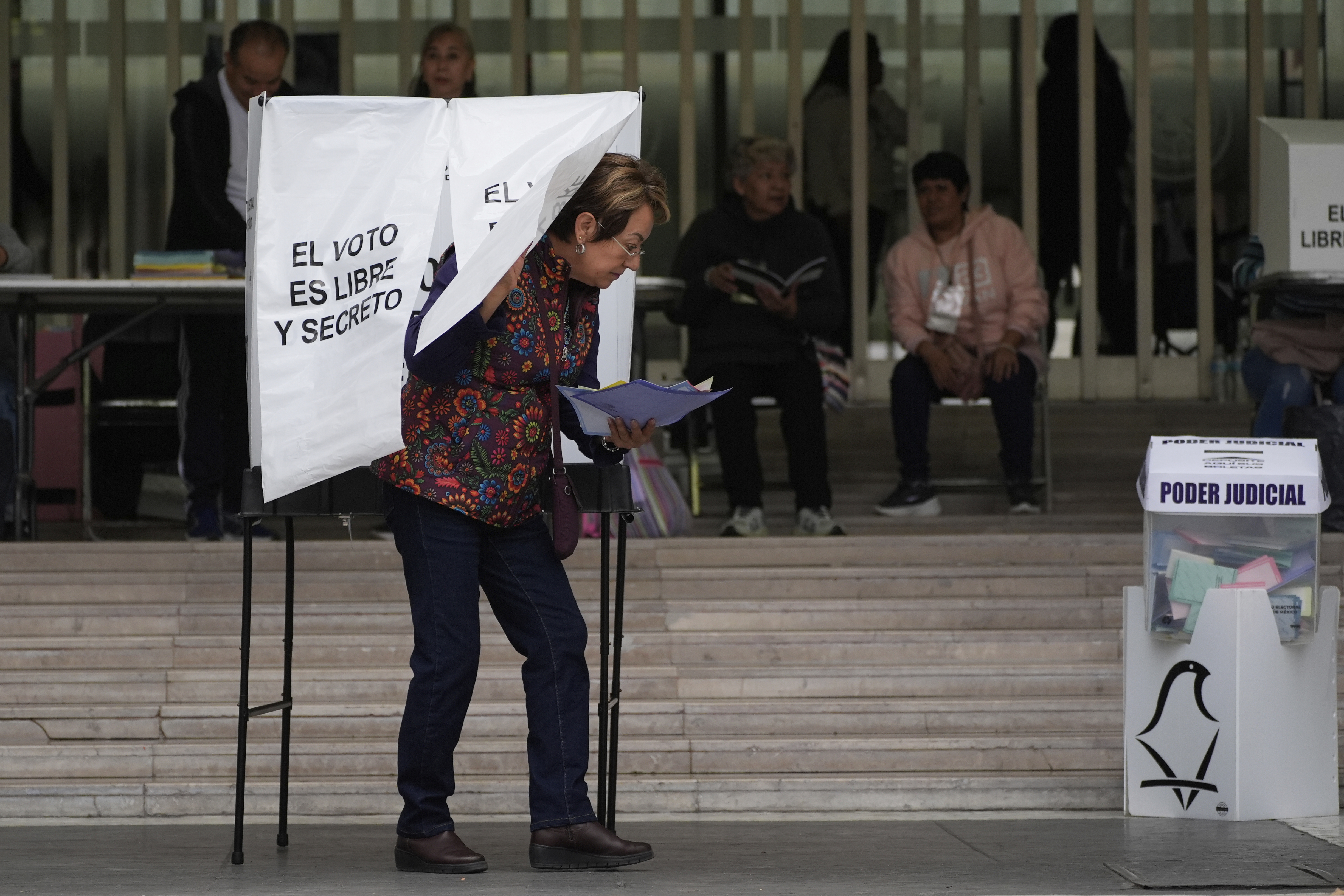 A voter leaves after casting her ballot in Mexico's first judicial elections, in Mexico City, Sunday, June 1, 2025. (AP Photo/Marco Ugarte)
