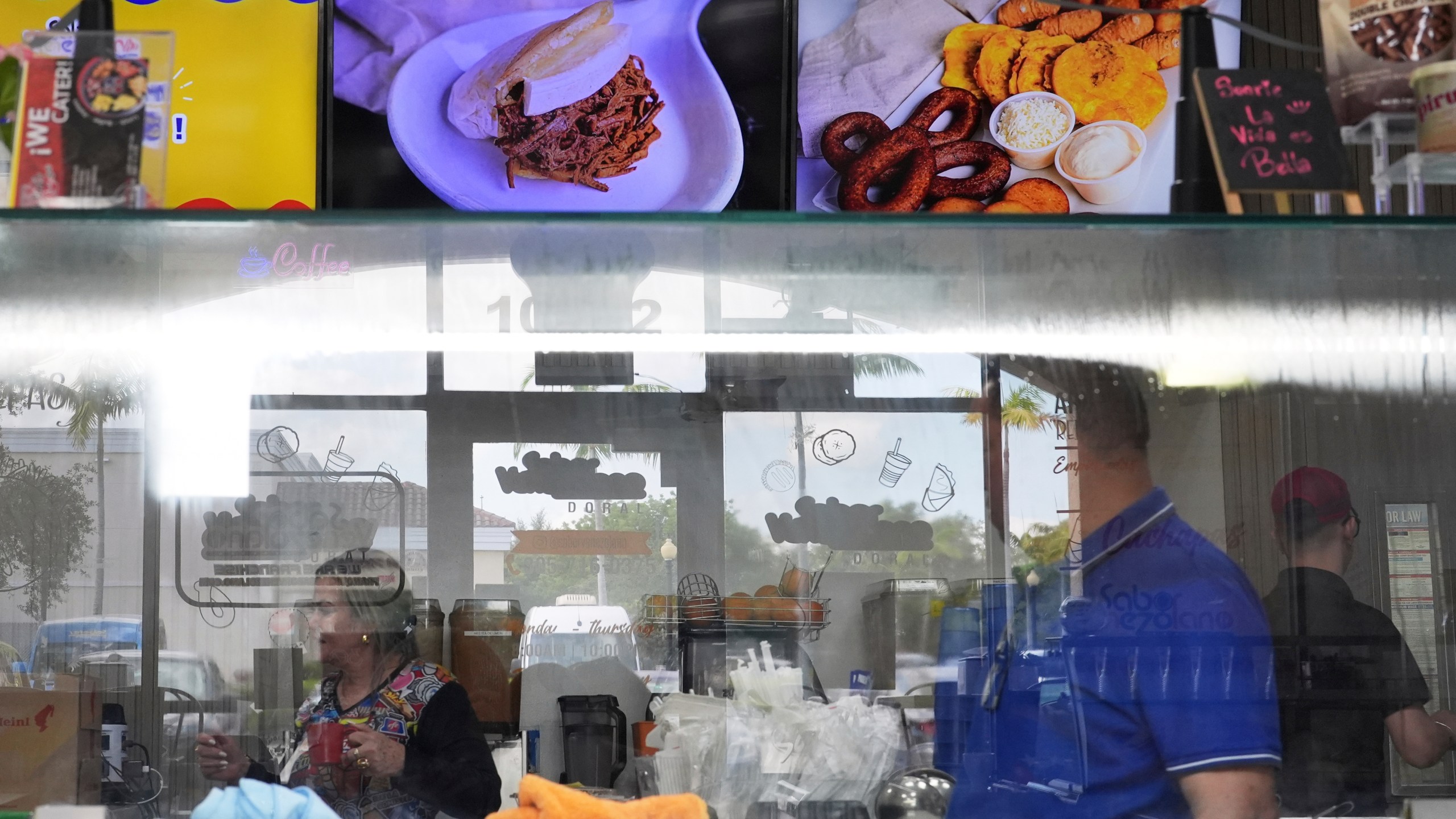 Employees work inside a franchise of "Sabor Venezolano," one of 18 businesses owned by Wilmer Escaray which employ scores of Venezuelan immigrants with Temporary Protected Status (TPS) who are now potentially exposed to deportation, in Doral, Fla., Tuesday, May 20, 2025. (AP Photo/Rebecca Blackwell)