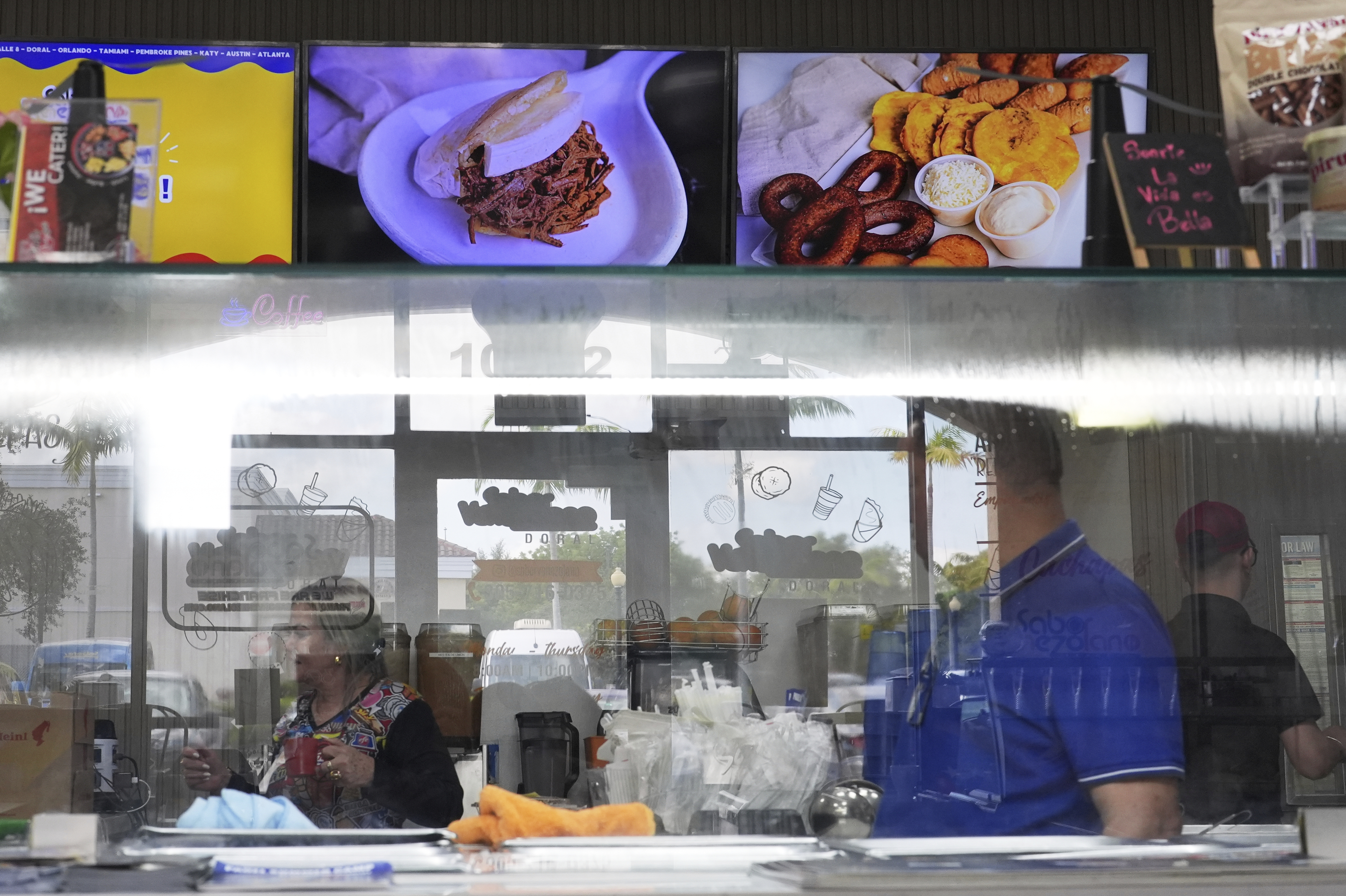 Employees work inside a franchise of "Sabor Venezolano," one of 18 businesses owned by Wilmer Escaray which employ scores of Venezuelan immigrants with Temporary Protected Status (TPS) who are now potentially exposed to deportation, in Doral, Fla., Tuesday, May 20, 2025. (AP Photo/Rebecca Blackwell)
