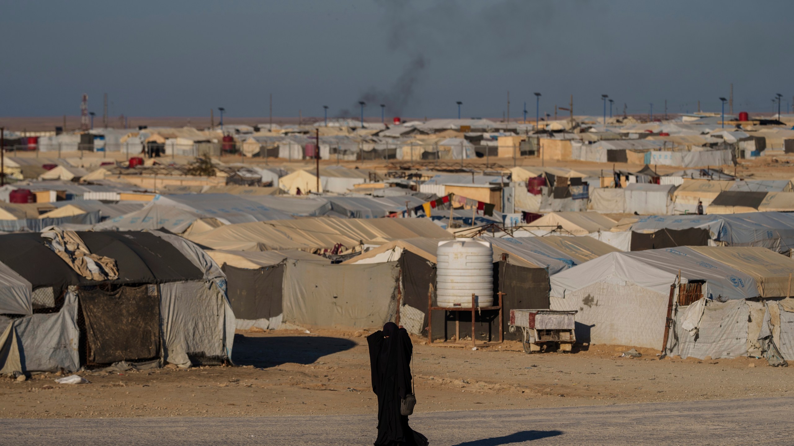 FILE - A woman walks in the al-Hol camp in northeastern Syria's Hasakeh province, where tens of thousands of mostly women and children linked to the Islamic State group have been living for years, Thursday, Jan. 30, 2025. (AP Photo/Bernat Armangue,File)