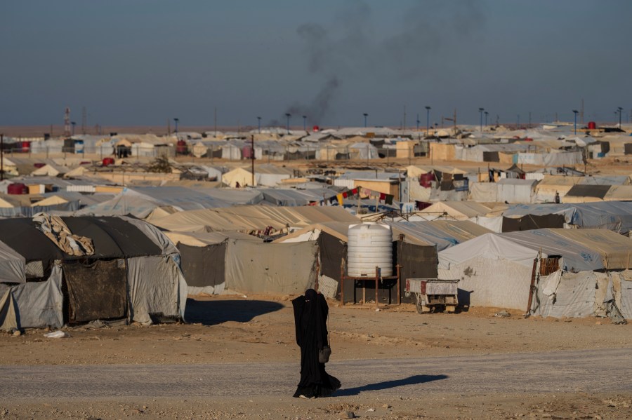FILE - A woman walks in the al-Hol camp in northeastern Syria's Hasakeh province, where tens of thousands of mostly women and children linked to the Islamic State group have been living for years, Thursday, Jan. 30, 2025. (AP Photo/Bernat Armangue,File)