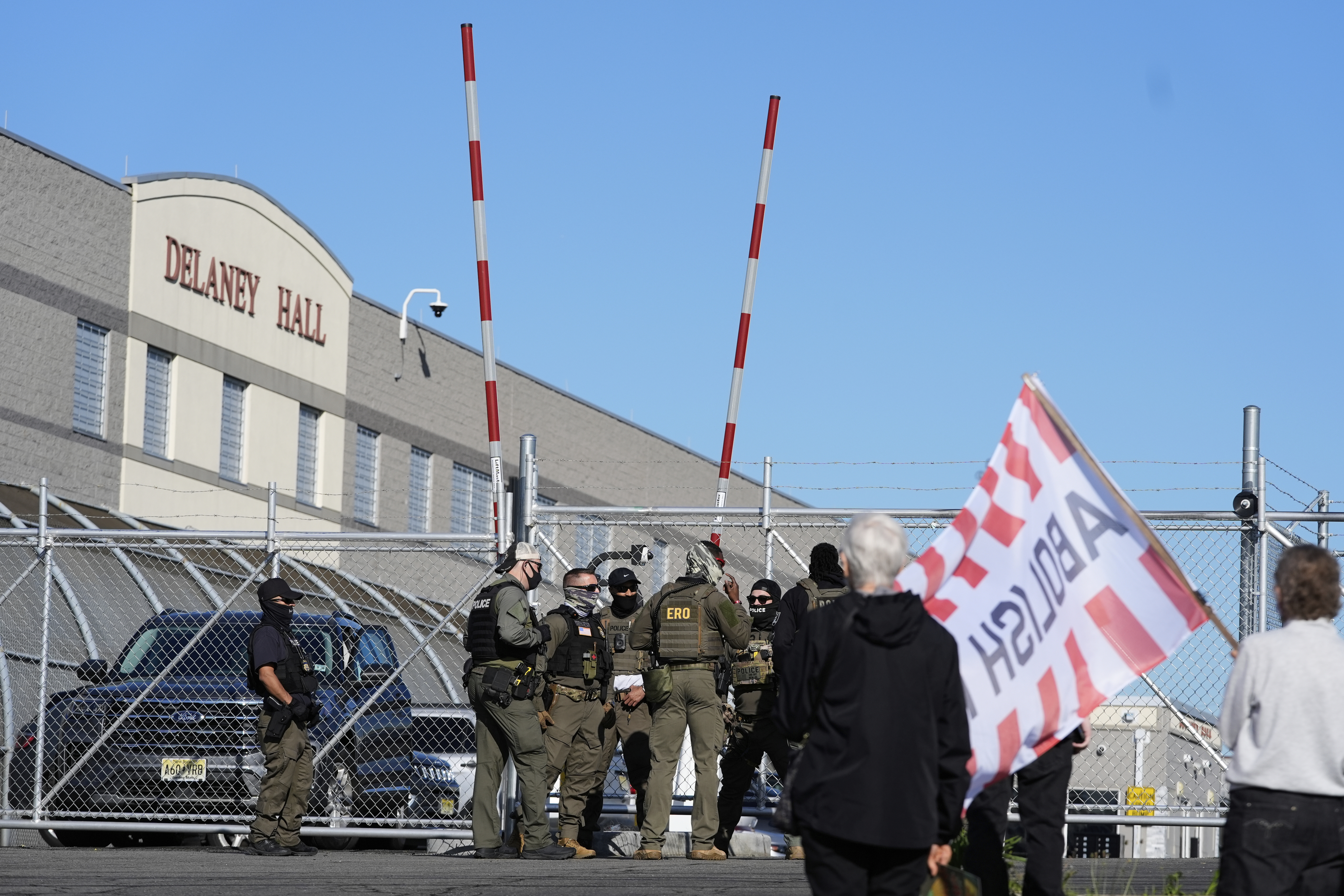 Protesters and security stand in front of Delaney Hall, a recently re-opened immigration detention center, in Newark, N.J., Wednesday, May 7, 2025. (AP Photo/Seth Wenig)
