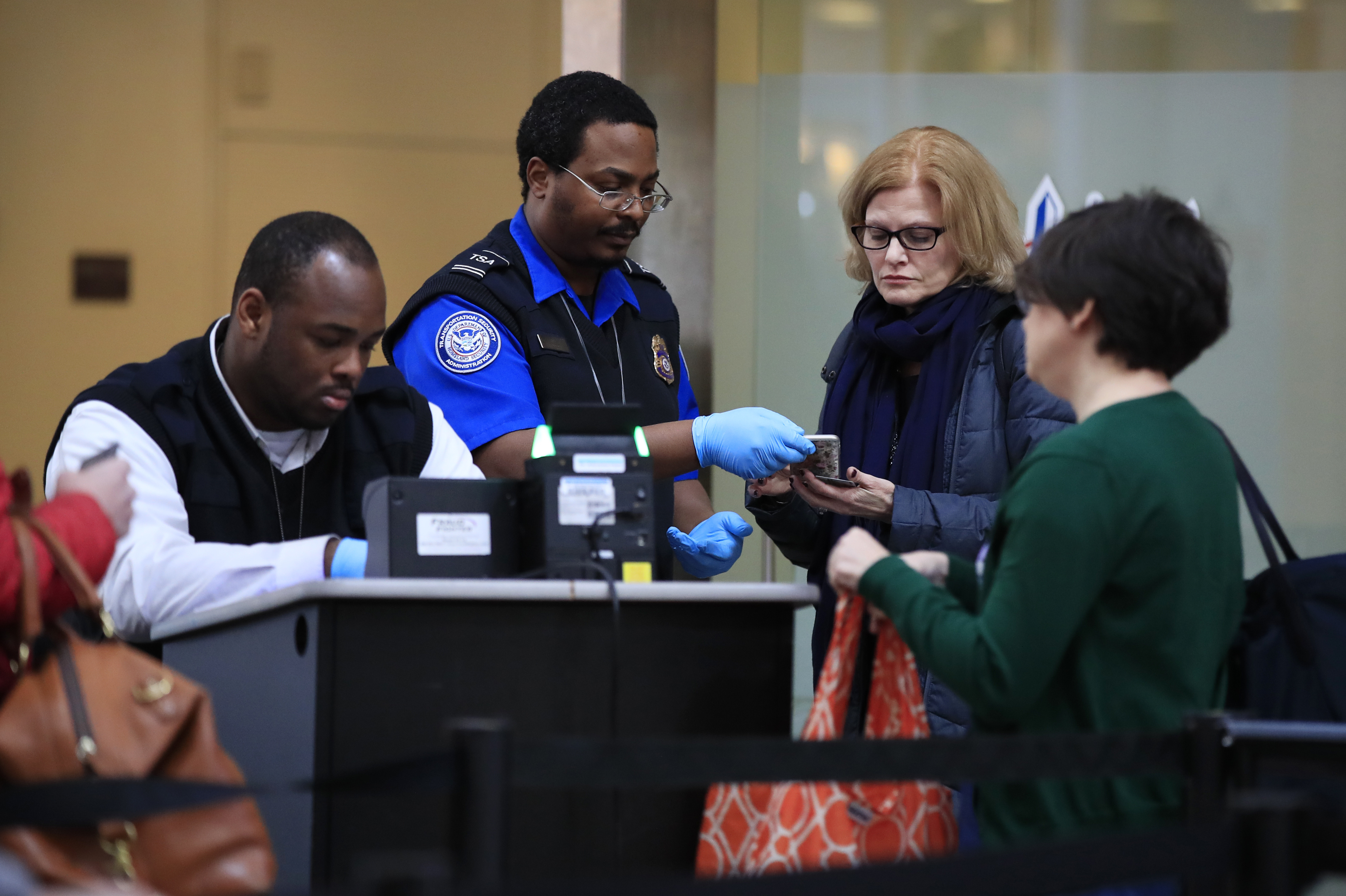FILE - Transportation Security Administration workers screen airline passengers at Reagan Washington National Airport in Washington, Monday, Jan. 28, 2019. (AP Photo/Manuel Balce Ceneta,File)