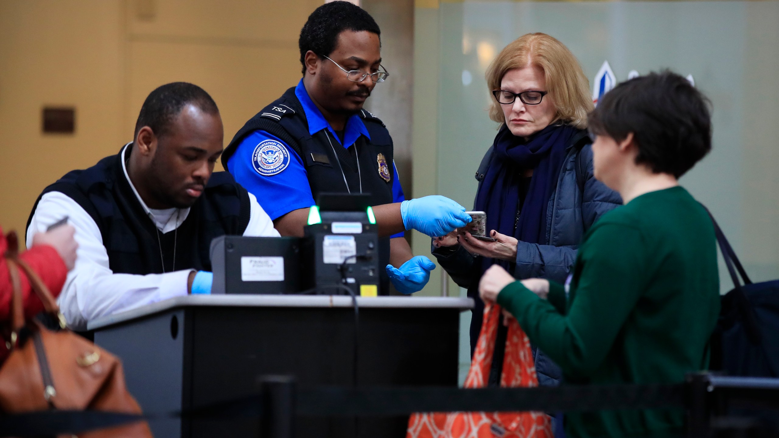 FILE - Transportation Security Administration workers screen airline passengers at Reagan Washington National Airport in Washington, Monday, Jan. 28, 2019. (AP Photo/Manuel Balce Ceneta,File)