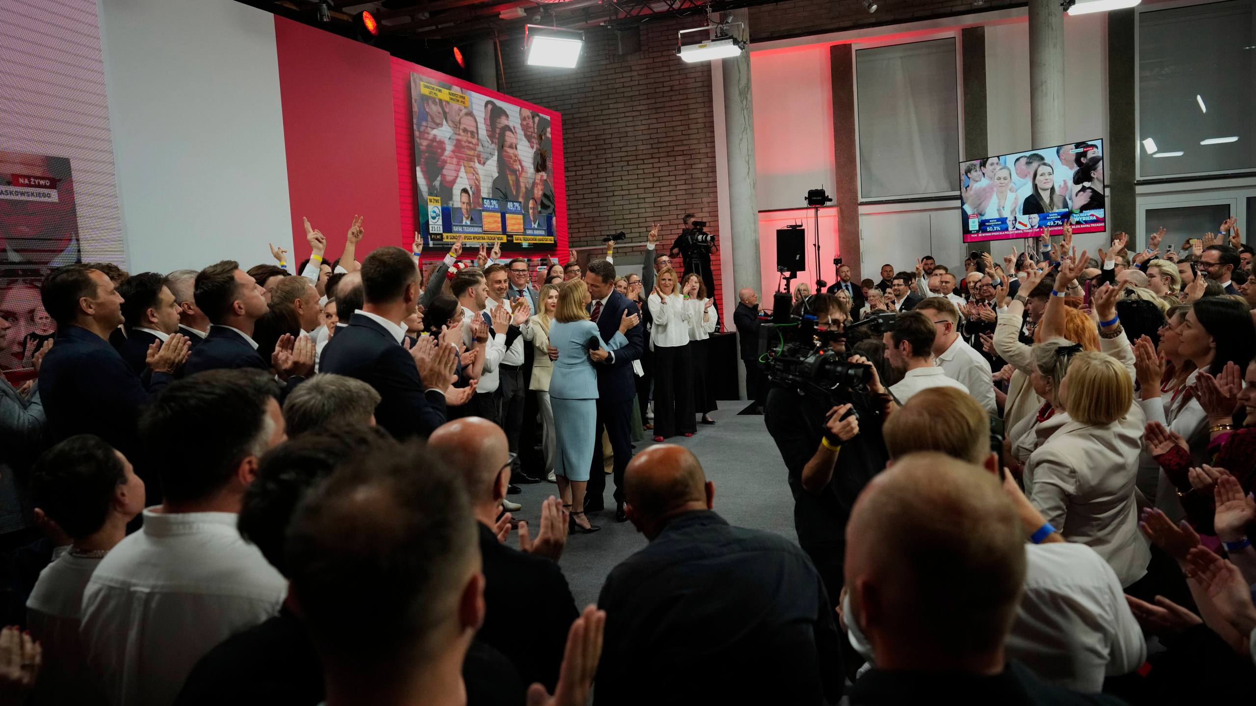 Presidential candidate Rafal Trzaskowski, a liberal pro-European Union figure, center, kisses his wife Malgorzata Trzaskowska at his headquarters after the presidential election runoff in Warsaw, Poland, Sunday, June 1, 2025. (AP Photo/Petr David Josek)