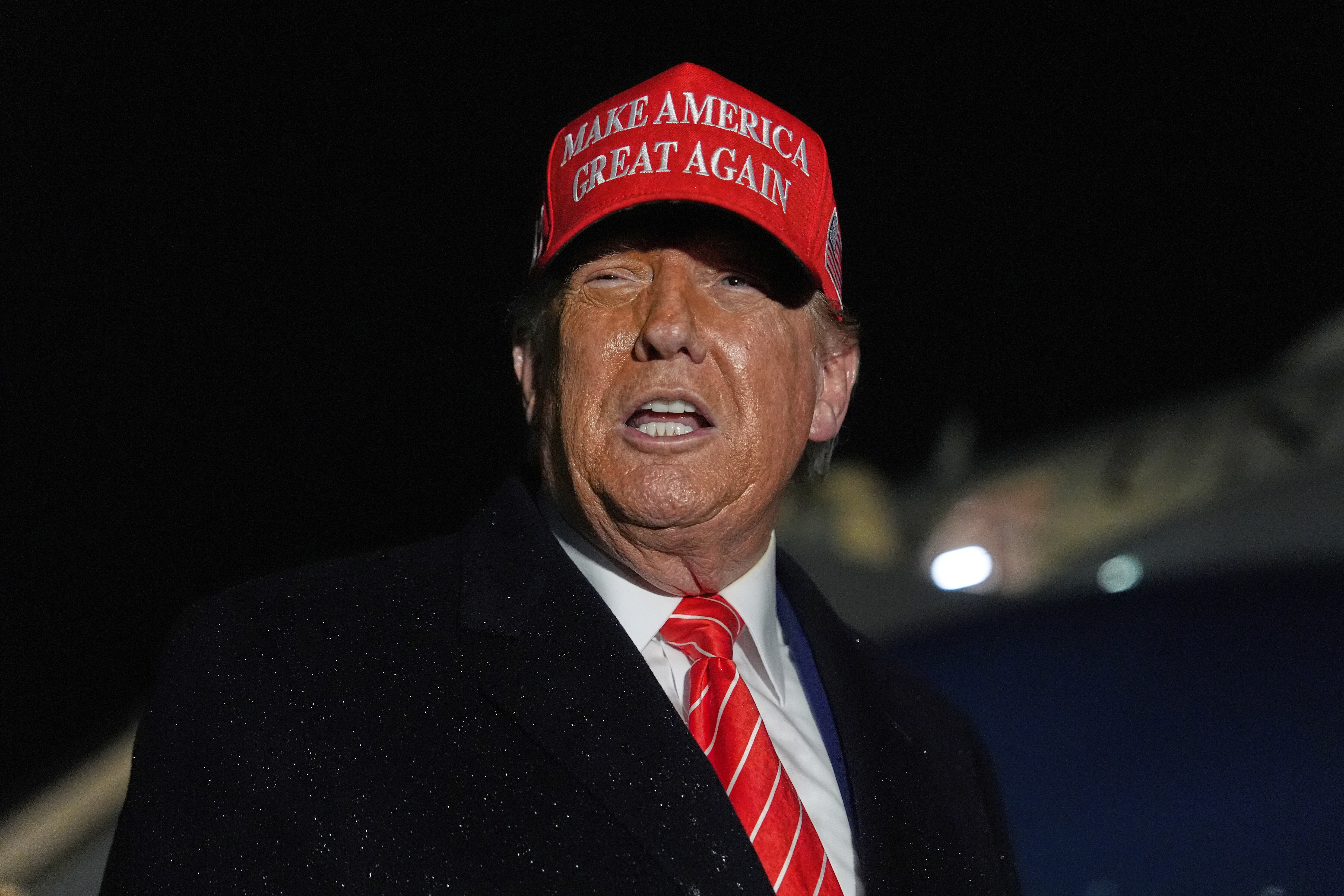 President Donald Trump speaks to reporters in the rain after arriving on Air Force One at Joint Base Andrews, Md., Friday, May 30, 2025. (AP Photo/Julia Demaree Nikhinson)