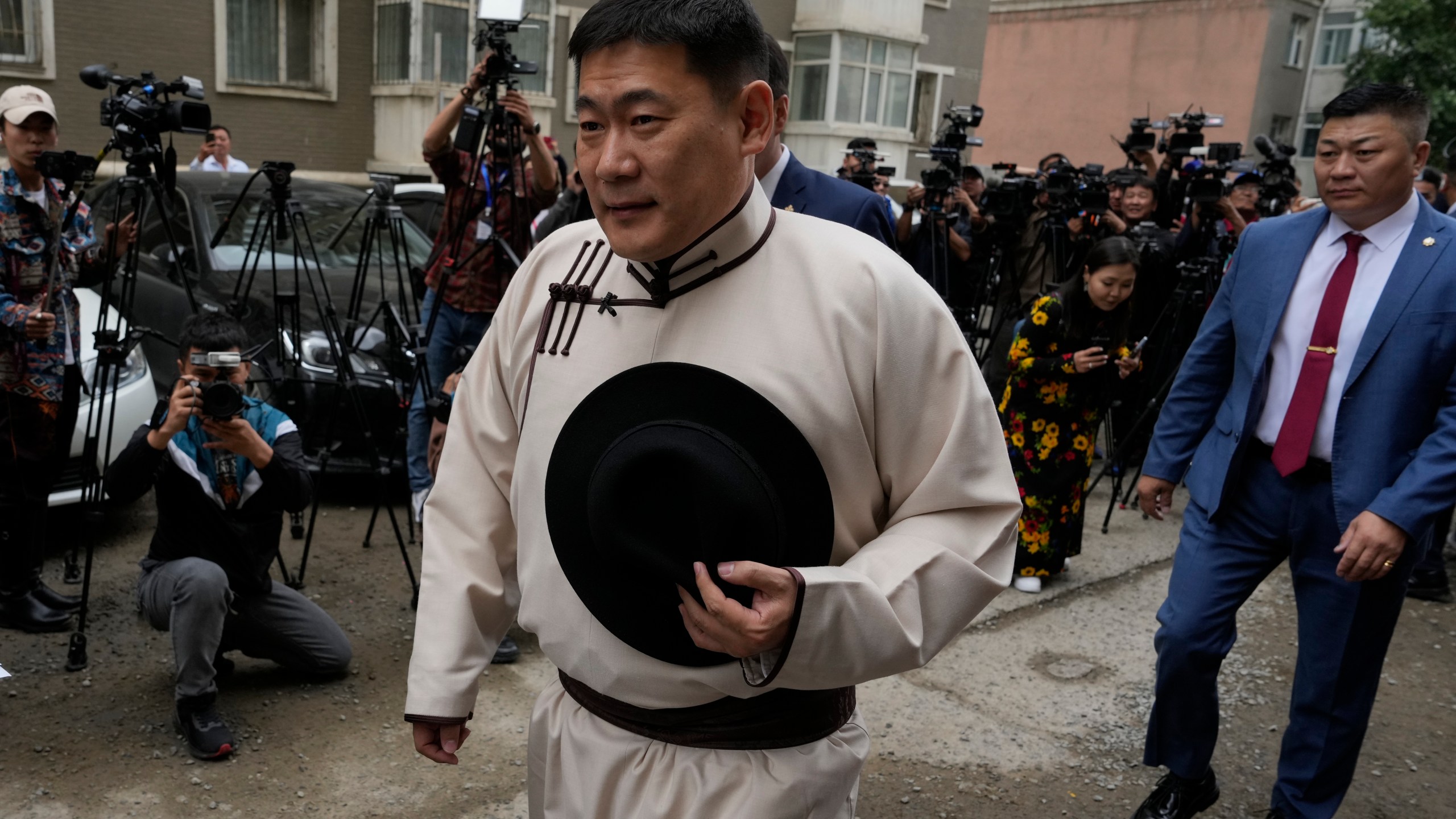 FILE -Mongolian Prime Minister Oyun-Erdene Luvsannamsrai walks past journalists as he arrives to vote at a polling station in Ulaanbataar, Mongolia, June 28, 2024. (AP Photo/Ng Han Guan, File)