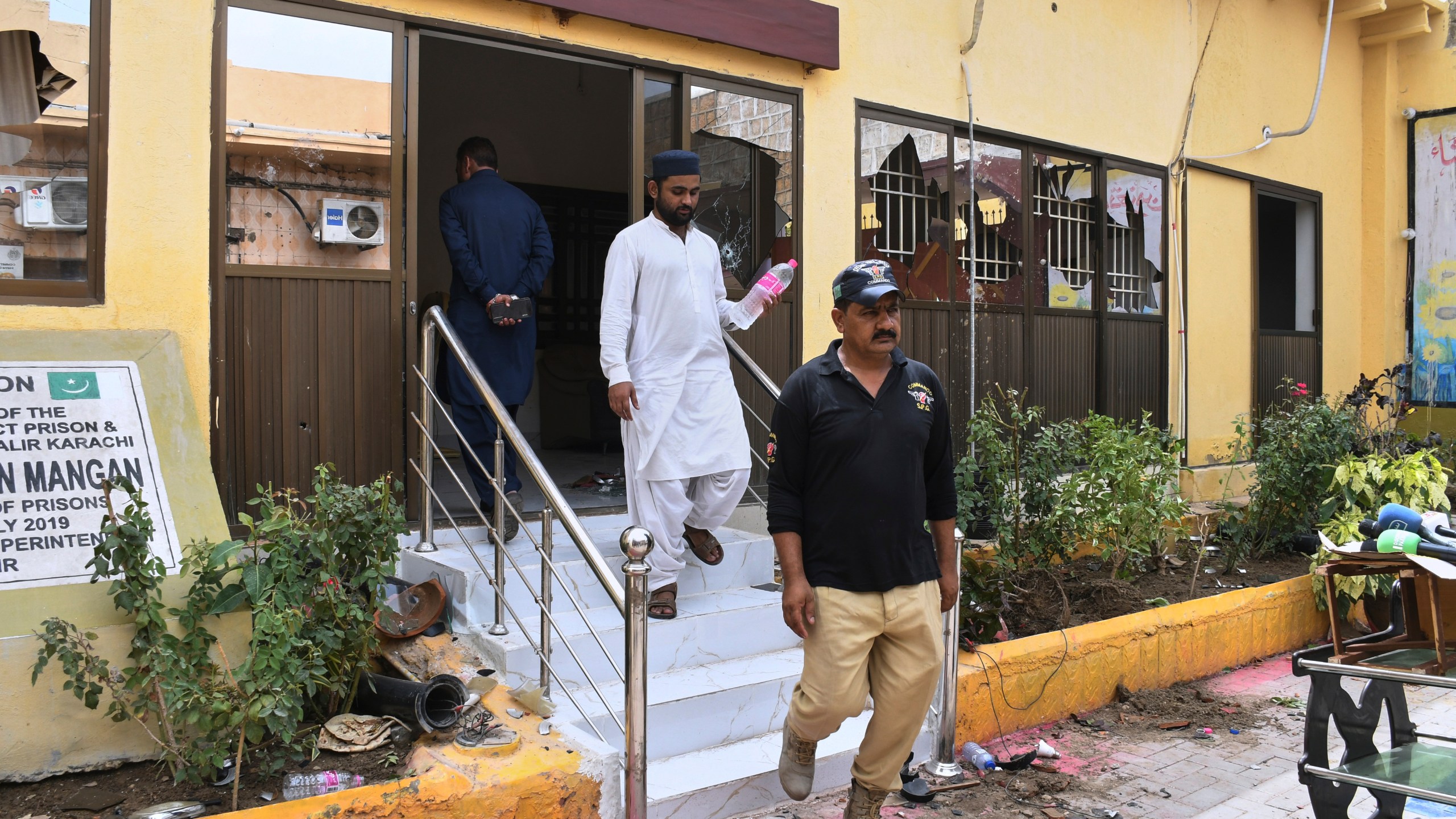 Police officers examine a damaged area inside the premises of the district Malir prison from where more than 100 inmates escaped overnight, in Karachi, Pakistan, Tuesday, June 3, 2025. (AP Photo/Ali Raza)