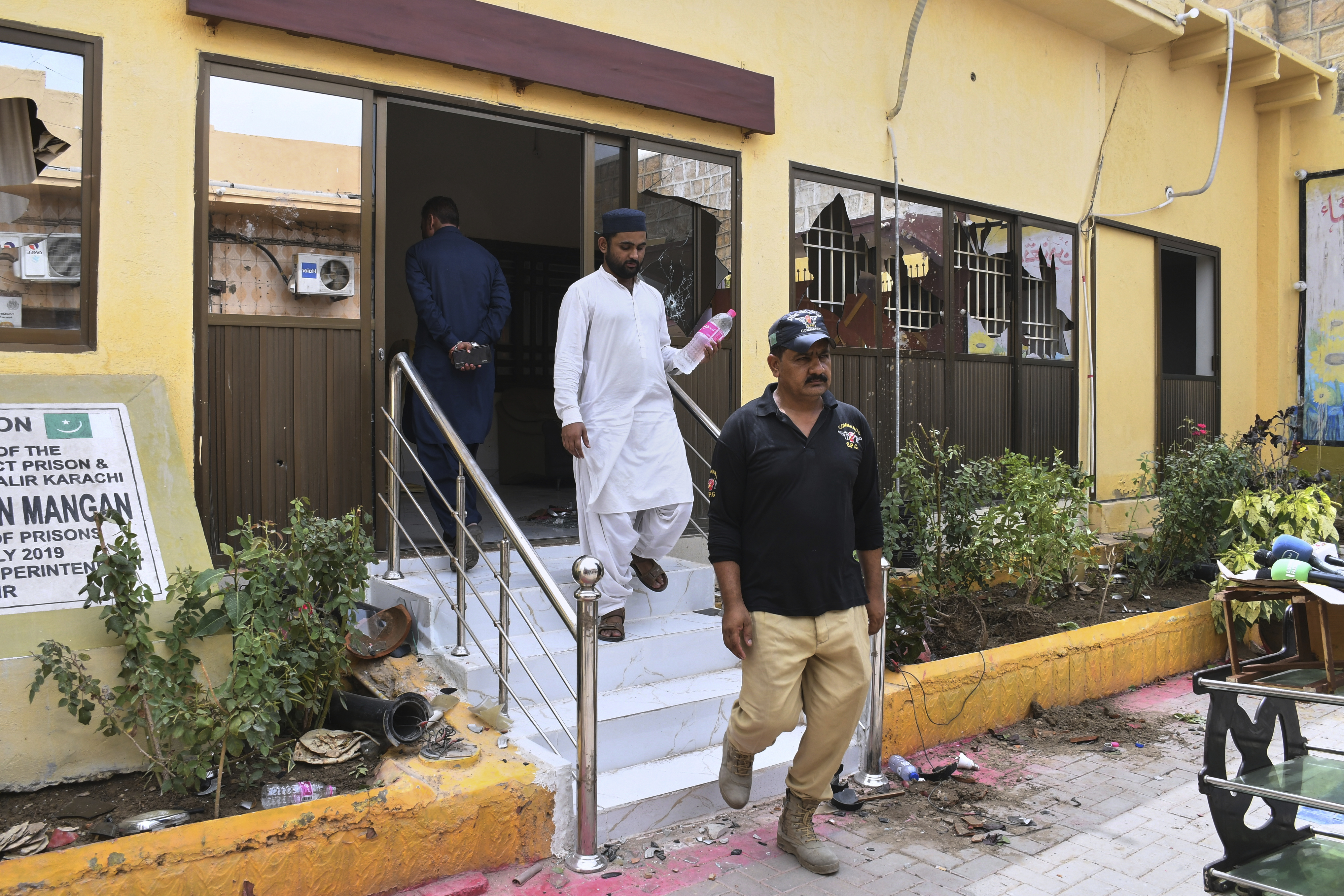 Police officers examine a damaged area inside the premises of the district Malir prison from where more than 100 inmates escaped overnight, in Karachi, Pakistan, Tuesday, June 3, 2025. (AP Photo/Ali Raza)