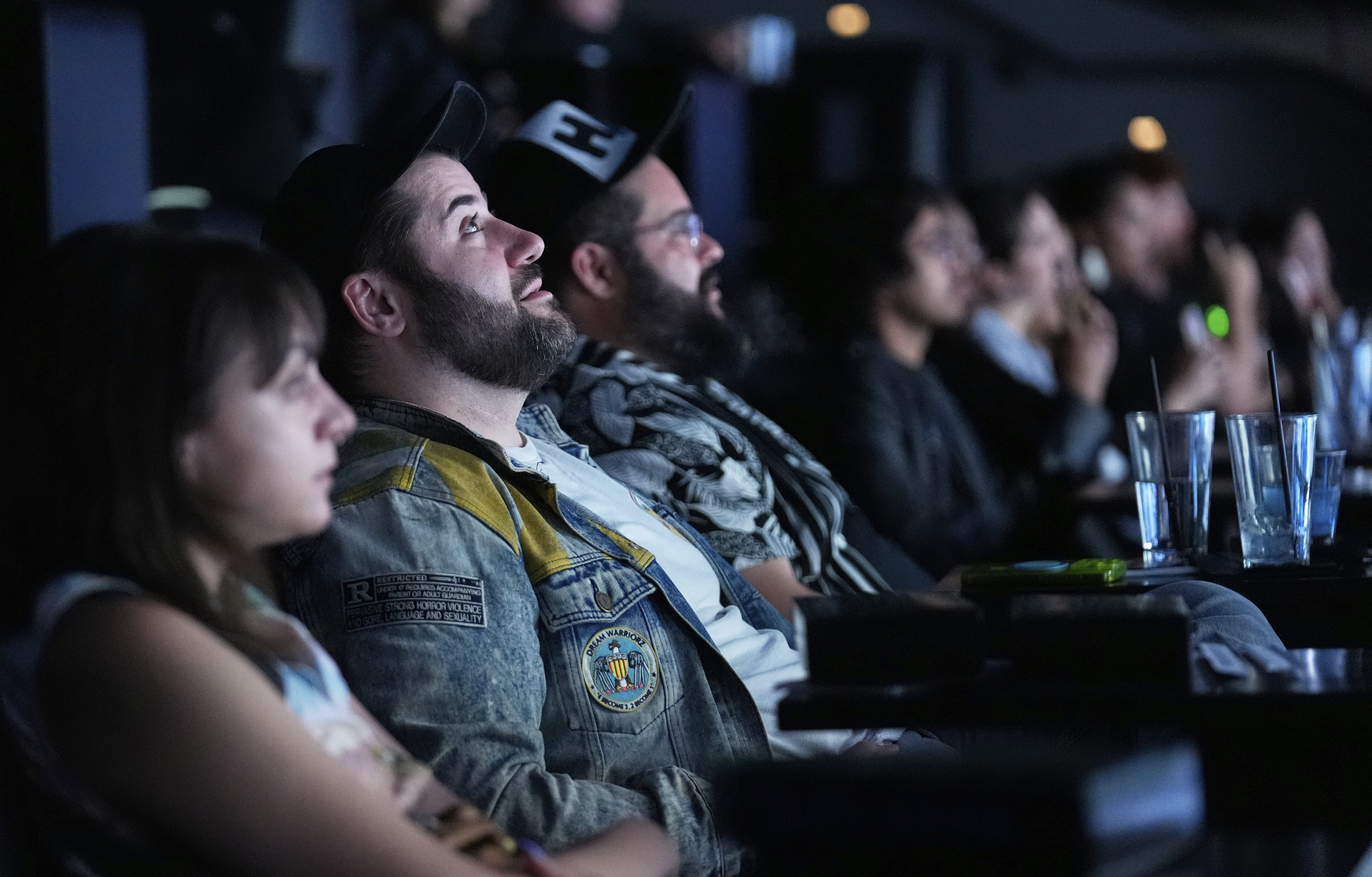 Audience member Matt Raub, second from left, watches immersive visuals above the movie screen during a screening of "The Matrix in Shared Reality" on Wednesday, May 28, 2025, at Cosm Los Angeles in Inglewood, Calif. (AP Photo/Chris Pizzello)