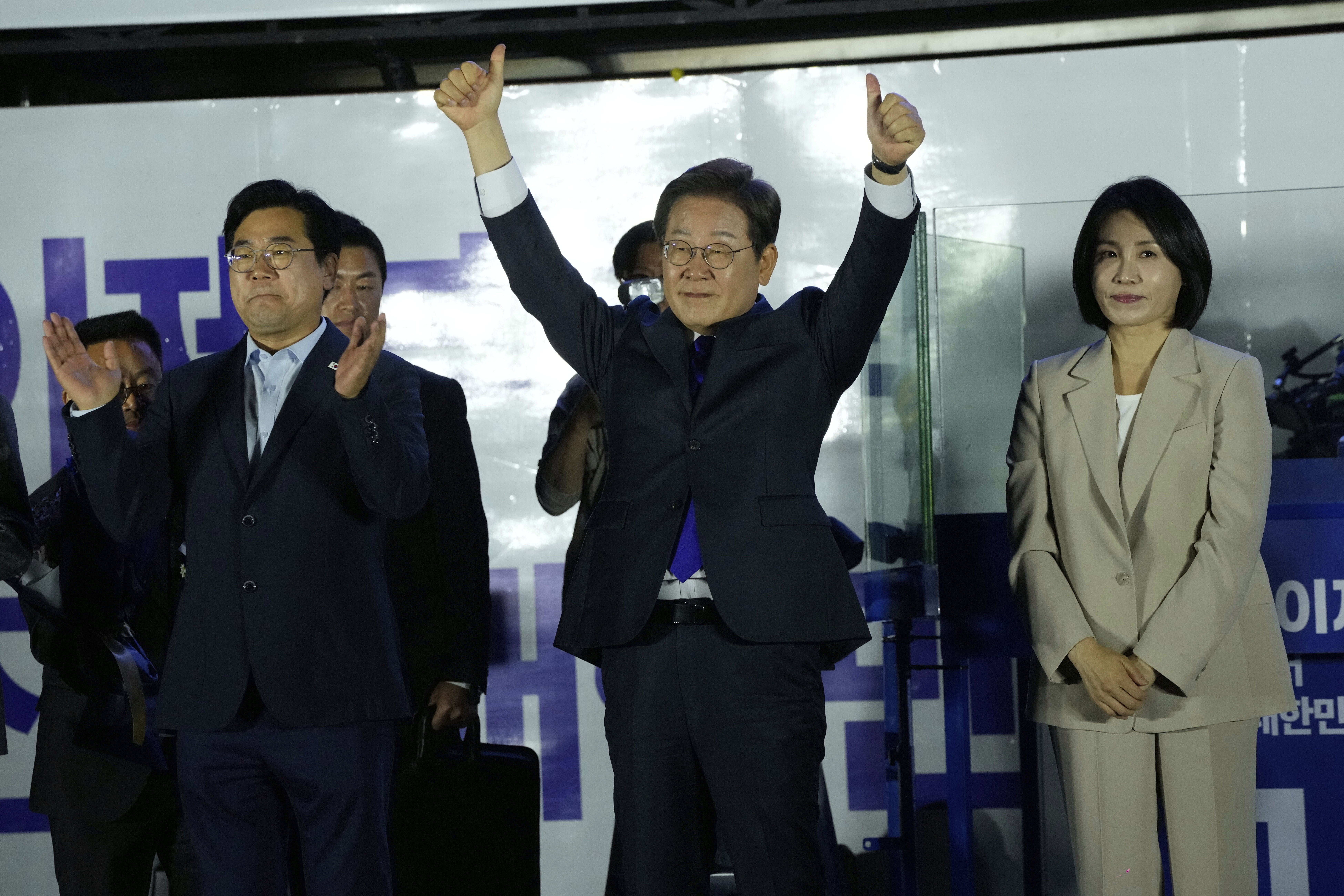 South Korea's Democratic Party's presidential candidate Lee Jae-myung, center, and his wife Kim Hea Kyung, right, greet supporters outside of the National Assembly in Seoul, South Korea, Wednesday, June 4, 2025. (AP Photo/Ahn Young-joon)