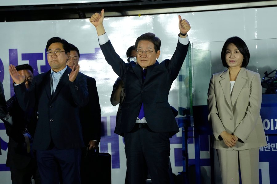 South Korea's Democratic Party's presidential candidate Lee Jae-myung, center, and his wife Kim Hea Kyung, right, greet supporters outside of the National Assembly in Seoul, South Korea, Wednesday, June 4, 2025. (AP Photo/Ahn Young-joon)