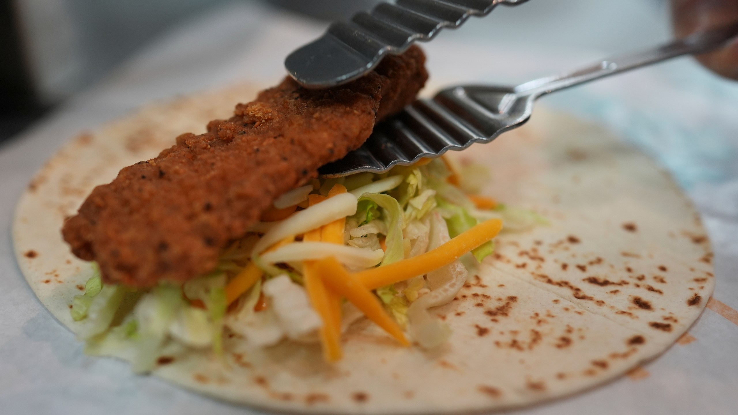 Charles L. Krumsiek, a McDonald's chef, puts a chicken on a tortilla to make a snack wrap at McDonald's Headquarter in Chicago, Thursday, May 29, 2025. (AP Photo/Nam Y. Huh)