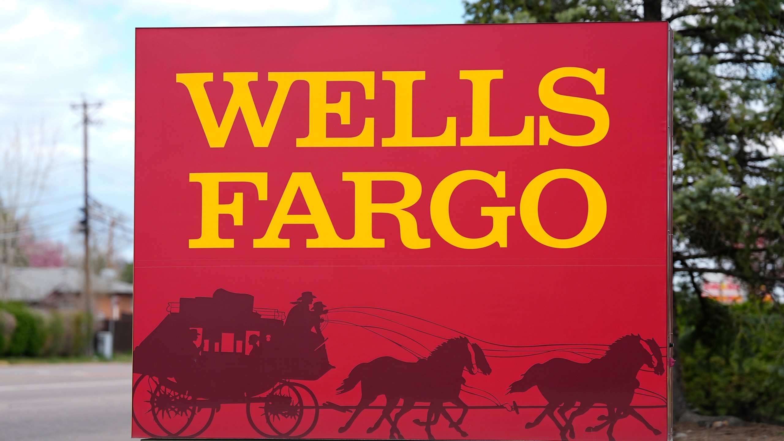 FILE - A sign stands outside a branch of Wells Fargo bank Wednesday, April 17, 2024, in Littleton, Colo. (AP Photo/David Zalubowski, File)