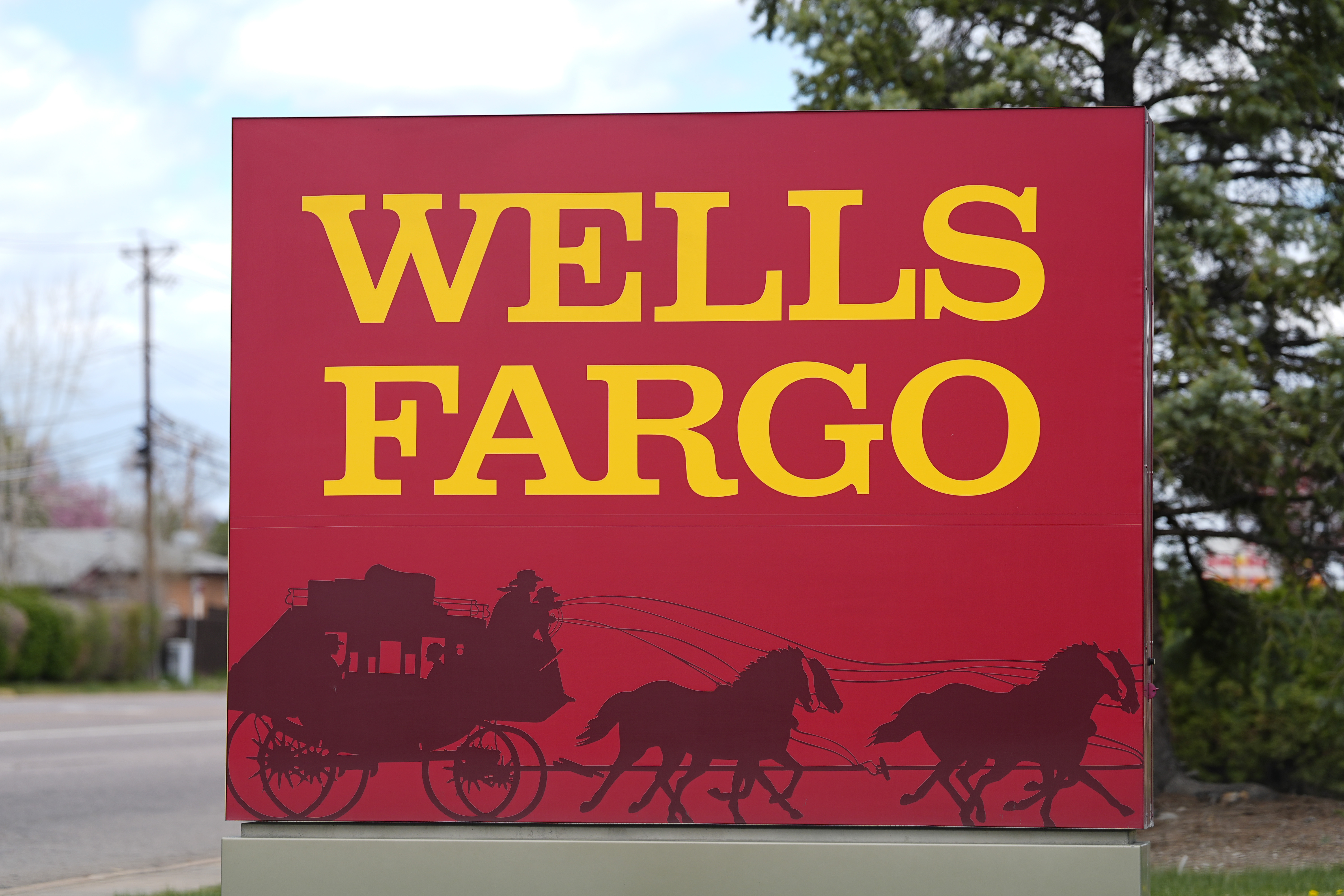 FILE - A sign stands outside a branch of Wells Fargo bank Wednesday, April 17, 2024, in Littleton, Colo. (AP Photo/David Zalubowski, File)