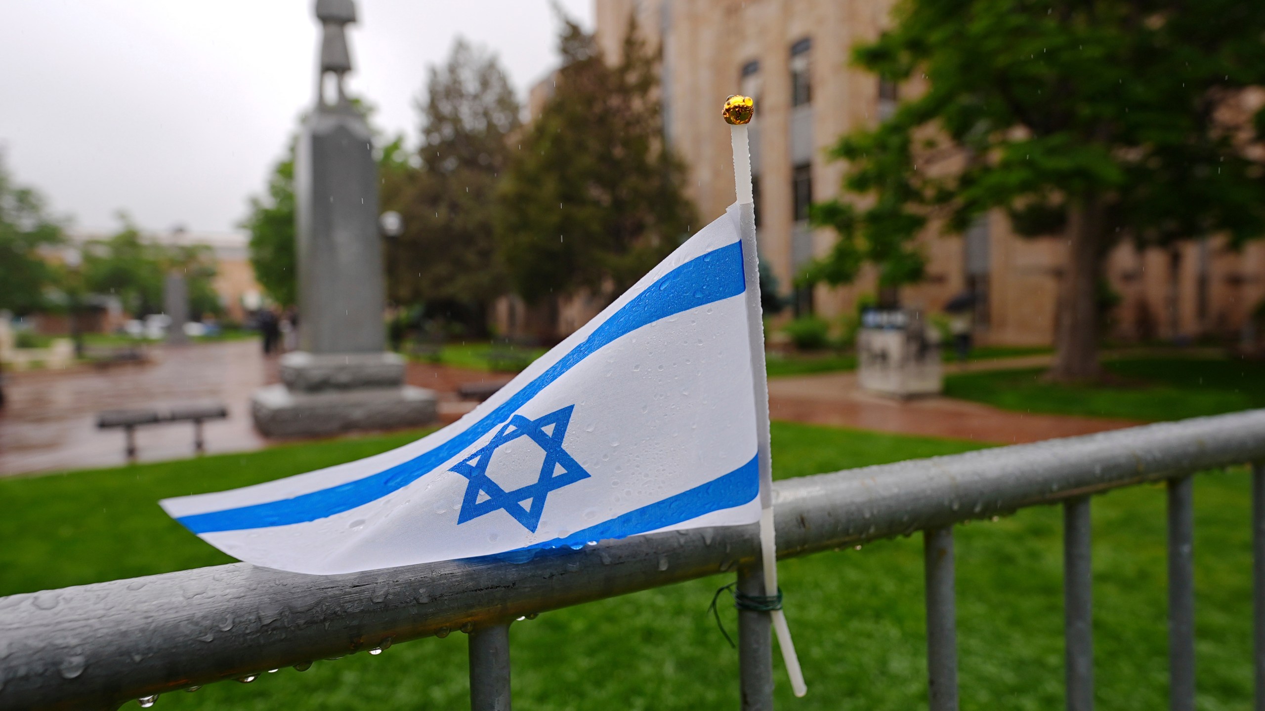 The flag of Israel tops a makeshift memorial for victims of an attack outside of the Boulder County, Colo., courthouse as a light rain falls Tuesday, June 3, 2025, in Boulder, Colo. (AP Photo/David Zalubowski)